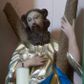 Zdjęcie nr 1: Rzeźba pełna, ustawiona na podstawie na planie kwadratu. Święty zwrócony frontalnie, z głową lekko skierowaną w prawo, w kontrapoście. Prawą rękę kładzie na piersi, lewą ujmuje ramię krzyża w kształcie litery „X”, stojącego za nim. Twarz ma pociągłą, o pełnych policzkach, dużych, migdałowatych oczach, prostym nosie i pełnych, rozchylonych ustach, okoloną brodą opadającą na pierś i falowanymi, brązowymi włosami sięgającymi ramion. Ubrany jest w srebrzoną, luźną tunikę oraz złocony płaszcz z niebieską podszewką zawiązany w partii nóg. Polichromia ciała naturalistyczna. 


