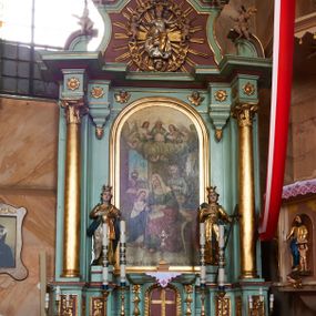 Zdjęcie nr 1: Nastawa architektoniczna, jednoosiowa, jednokondygnacyjna ze zwieńczeniem, ustawiona na cokole z wyodrębnionymi czterema prostopadłościanami. Ołtarz murowany, prostopadłościenny, rozszerzający się ku górze. Mensa kamienna, z kamiennym portatylem. Antepedium marmoryzowane z malowaną iluzjonistycznie płyciną. 
Tabernakulum w formie prostopadłościennej skrzynki, o wypukłym froncie, zwieńczonej profilowanym gzymsem. Drzwiczki w kształcie stojącego prostokąta zamkniętego półkoliście, ujęte obwódką utworzoną z liści, dekorowane płaskorzeźbionym wizerunkiem krzyża i panoramą miasta; flankowane roślinnymi zwisami. Retabulum ujęte parą kolumn o kapitelach korynckich dźwigających pełne belkowanie, wyłamane na ich osi. Po wewnętrznej stronie z wyłamanymi impostami podtrzymywanymi na wspornikach zakończonych szyszkami. Belkowanie o architrawie i fryzie przerwanymi polem środkowym, z silnie wysuniętym gzymsem i fragmentami półkolistego, przerwanego przyczółka. Fryz dekorowany rozetami. Pole środkowe w formie wnęki o kształcie stojącego prostokąta zamkniętego łukiem półkolistym, ujętej profilowaną ramą, z obrazem Nauczania Marii. Obraz flankują figury św. Apolonii i św. Heleny. Zwieńczenie w formie zbliżonej do trapezu, o wklęsłych bokach, zamkniętego łukiem segmentowym nadwieszonym. W polu płycina o tym samym kształcie z rzeźbiarskim przedstawieniem Marii siedzącej na obłoku, na tle krzyża, ujętej wieńcem roślinnym z aniołkami i uskrzydlonymi główkami anielskimi, w glorii promienistej. Gzyms i zwieńczenie z siedzącymi puttami oraz uskrzydlonymi główkami anielskimi. Struktura polichromowana w kolorze jasnozielonym, z czerwonymi detalami, złoconymi kolumnami, ornamentyką i profilami. 
