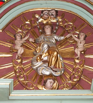 Zdjęcie nr 8: Nastawa architektoniczna, jednoosiowa, jednokondygnacyjna ze zwieńczeniem, ustawiona na cokole z wyodrębnionymi czterema prostopadłościanami. Ołtarz murowany, prostopadłościenny, rozszerzający się ku górze. Mensa kamienna, z kamiennym portatylem. Antepedium marmoryzowane z malowaną iluzjonistycznie płyciną. 
Tabernakulum w formie prostopadłościennej skrzynki, o wypukłym froncie, zwieńczonej profilowanym gzymsem. Drzwiczki w kształcie stojącego prostokąta zamkniętego półkoliście, ujęte obwódką utworzoną z liści, dekorowane płaskorzeźbionym wizerunkiem krzyża i panoramą miasta; flankowane roślinnymi zwisami. Retabulum ujęte parą kolumn o kapitelach korynckich dźwigających pełne belkowanie, wyłamane na ich osi. Po wewnętrznej stronie z wyłamanymi impostami podtrzymywanymi na wspornikach zakończonych szyszkami. Belkowanie o architrawie i fryzie przerwanymi polem środkowym, z silnie wysuniętym gzymsem i fragmentami półkolistego, przerwanego przyczółka. Fryz dekorowany rozetami. Pole środkowe w formie wnęki o kształcie stojącego prostokąta zamkniętego łukiem półkolistym, ujętej profilowaną ramą, z obrazem Nauczania Marii. Obraz flankują figury św. Apolonii i św. Heleny. Zwieńczenie w formie zbliżonej do trapezu, o wklęsłych bokach, zamkniętego łukiem segmentowym nadwieszonym. W polu płycina o tym samym kształcie z rzeźbiarskim przedstawieniem Marii siedzącej na obłoku, na tle krzyża, ujętej wieńcem roślinnym z aniołkami i uskrzydlonymi główkami anielskimi, w glorii promienistej. Gzyms i zwieńczenie z siedzącymi puttami oraz uskrzydlonymi główkami anielskimi. Struktura polichromowana w kolorze jasnozielonym, z czerwonymi detalami, złoconymi kolumnami, ornamentyką i profilami. 
