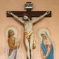 Zdjęcie nr 1: Rzeźba Chrystusa Ukrzyżowanego  między polichromowanymi na ścianie kościoła postaciami św. Jana Ewangelisty z lewej i Marii z prawej strony. Chrystus ukazany w lekkim zwisie, z wyprężonym ciałem, przybity do krzyża trzema gwoździami. Głowa opada mu na prawe ramię, oczy ma zamknięte, nos wąski, usta niewielki. Włosy opadają mu na plecy, ma krótkie wąsy i brodę. Jest przepasany  złotym perizonium. Nad głową ma titulus z napisem „INRI” pod stopami z napisem „Pamiątka ze starego kościoła”. Polichromia w partiach ciała naturalistyczna. 
Po lewej stronie krzyża młodzieńcze przedstawienie Jana Ewangelisty w  żółtej tunice i błękitnym płaszczu. Jest zwrócony w trzech czwartych w lewo, głowę kieruje w stronę Chrystusa, ręce ma złożone do modlitwy. Ma owalną twarz, ciemne oczy, wąski nos i  mięsiste usta, ciemnoblond włosy opadają my na kark. Matka Boska stoi po prawej stronie, zwrócona w stronę krzyża, ze spuszczoną głową; załamuje ręce. Ma smutną w wyrazie twarz, zamknięte oczy, duży nos i szerokie usta. Jest ubrana w różową suknię i błękitny płaszcz, na głowę ma zarzuconą białą chustę. Wokół głów postaci jasne nimby, ich ciała otoczone kreskowaniem, pod stopami zaznaczona linia ziemi. 
