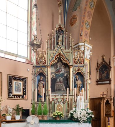 Zdjęcie nr 1: Ołtarz przyścienny, architektoniczny, trójosiowy, jednokondygnacyjny ze zwieńczeniem. Mensa skrzyniowa, prostopadłościenna, z antepedium dekorowanym płycinami. W środkowej plakieta z symbolami płonącego serca oplecionego koroną cierniową, krzyża i kotwicy ujętymi kwitnącymi kwiatami i liśćmi. Na mensie tabernakulum w formie prostopadłościanu zwieńczonego wimpergą wypełnioną uskrzydlonymi główkami anielskimi, ujetą pinaklami. W centrum ostrołukowe drzwiczki z podobizną ukrzyżoanego Chrystusa. Predella trójdzielna ze środkową częścią wyższą, dekorowana fryzem z przenikających się arkadek, w środkowej części flankowanym blendami. W pierwszej kondygnacji retabulum trzy nisze prostokątne, z których środkowa zamknięta trójlistnie a boczne trójkątnie. Środkowa nisza wyższa i szersza od bocznych, rama dekorowana ornamentem, wszystkie zdobione ażurowym ornamentem roślinnym i żabkami; szczyty z fragmentami ornamentyki geometryczno-roślinnej. Boczne nisze zwieńczone pinaklami, między którymi przenikające się żebra zwieńczone kwiatonem i fragmentami wolut, wypełnione wicią roślinną. W środkowej niszy kondygnacji obraz z przedstawieniem Matki Boskiej Różańcowej, w bocznych figury biskupów. Kondygnacja ujęta uszami utworzonymi z przypór z pinaklami. W zwieńczeniu ażurowa kapliczka ujęta pinaklami, w której figura św. Jacka. 
Struktura jasnozielona, nisze niebieskie, fragmenty dekoracji czerwone i niebieskie, detale złocone. 
