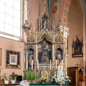 Zdjęcie nr 1: Ołtarz przyścienny, architektoniczny, trójosiowy, jednokondygnacyjny ze zwieńczeniem. Mensa skrzyniowa, prostopadłościenna, z antepedium dekorowanym płycinami. W środkowej plakieta z symbolami płonącego serca oplecionego koroną cierniową, krzyża i kotwicy ujętymi kwitnącymi kwiatami i liśćmi. Na mensie tabernakulum w formie prostopadłościanu zwieńczonego wimpergą wypełnioną uskrzydlonymi główkami anielskimi, ujetą pinaklami. W centrum ostrołukowe drzwiczki z podobizną ukrzyżoanego Chrystusa. Predella trójdzielna ze środkową częścią wyższą, dekorowana fryzem z przenikających się arkadek, w środkowej części flankowanym blendami. W pierwszej kondygnacji retabulum trzy nisze prostokątne, z których środkowa zamknięta trójlistnie a boczne trójkątnie. Środkowa nisza wyższa i szersza od bocznych, rama dekorowana ornamentem, wszystkie zdobione ażurowym ornamentem roślinnym i żabkami; szczyty z fragmentami ornamentyki geometryczno-roślinnej. Boczne nisze zwieńczone pinaklami, między którymi przenikające się żebra zwieńczone kwiatonem i fragmentami wolut, wypełnione wicią roślinną. W środkowej niszy kondygnacji obraz z przedstawieniem Matki Boskiej Różańcowej, w bocznych figury biskupów. Kondygnacja ujęta uszami utworzonymi z przypór z pinaklami. W zwieńczeniu ażurowa kapliczka ujęta pinaklami, w której figura św. Jacka. 
Struktura jasnozielona, nisze niebieskie, fragmenty dekoracji czerwone i niebieskie, detale złocone. 

