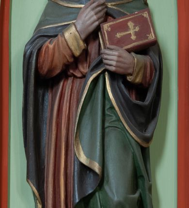 Zdjęcie nr 2: Ambona wisząca, przyścienna składająca się z kosza, zaplecka, baldachimu i schodów z balustradą. Kosz na planie wieloboku, podzielony na pola kolumienkami podtrzymującymi belkowanie, którego gzyms stanowi parapet. W polach płyciny w formie stojącego prostokąta zamkniętego łukiem ostrym. W płycinach całopostaciowe figury ewangelistów – od strony schodów – św. Jan, św. Marek, św. Łukasz i św. Mateusz. Każdy z nich ubrany w długą suknię, z narzuconym płaszczem, trzyma w rękach księgę lub zwój i ma (prócz Łukasza) przy nodze właściwy atrybut. Rzeźby są wolnostojące, na cokołach z podpisami. Wzdłuż ramy dolnej ażurowy ornament maswerkowy. Podstawa zwęża się ku dołowi, ścięta płasko. Zaplecek w kształcie stojącego prostokąta, wypełniony płyciną zamkniętą łukiem ostrym, ze zdwojonym łukiem i rozetą z czworoliściem.  Rozbudowany baldachim powtarza kształt kosza, składa się z arkad ujmujących zwieńczenie w formie kapliczki. Arkady od wewnątrz zdobi maswerkowy fryz, a wieńczą trójkątne, ażurowe szczyty z żabkami i kwiatonami. Wieńcząca kapliczka dwukondygnacyjna, z pinaklami, żabkami i kwiatonami; najwyższe pinakiel zakończony krzyżem. Struktura jasnozielona, niektóre elementy niebieskie lub czerwone, profile i ornamenty złocone.