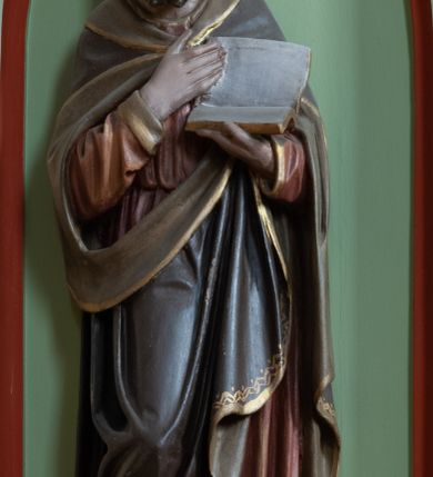 Zdjęcie nr 4: Ambona wisząca, przyścienna składająca się z kosza, zaplecka, baldachimu i schodów z balustradą. Kosz na planie wieloboku, podzielony na pola kolumienkami podtrzymującymi belkowanie, którego gzyms stanowi parapet. W polach płyciny w formie stojącego prostokąta zamkniętego łukiem ostrym. W płycinach całopostaciowe figury ewangelistów – od strony schodów – św. Jan, św. Marek, św. Łukasz i św. Mateusz. Każdy z nich ubrany w długą suknię, z narzuconym płaszczem, trzyma w rękach księgę lub zwój i ma (prócz Łukasza) przy nodze właściwy atrybut. Rzeźby są wolnostojące, na cokołach z podpisami. Wzdłuż ramy dolnej ażurowy ornament maswerkowy. Podstawa zwęża się ku dołowi, ścięta płasko. Zaplecek w kształcie stojącego prostokąta, wypełniony płyciną zamkniętą łukiem ostrym, ze zdwojonym łukiem i rozetą z czworoliściem.  Rozbudowany baldachim powtarza kształt kosza, składa się z arkad ujmujących zwieńczenie w formie kapliczki. Arkady od wewnątrz zdobi maswerkowy fryz, a wieńczą trójkątne, ażurowe szczyty z żabkami i kwiatonami. Wieńcząca kapliczka dwukondygnacyjna, z pinaklami, żabkami i kwiatonami; najwyższe pinakiel zakończony krzyżem. Struktura jasnozielona, niektóre elementy niebieskie lub czerwone, profile i ornamenty złocone.