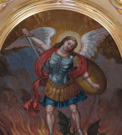 Zdjęcie nr 1: Obraz w kształcie stojącego owalu w profilowanej, złoconej ramie z przedstawieniem św. Michała Archanioła walczącego z szatanem. W centrum kompozycji archanioł w momencie ataku wznosi się powyżej szatana na rozpostartych, złożonych z piór skrzydłach, opierając na nim obie stopy. W prawej ręce trzyma skierowany ostrzem w stronę diabła miecz, w lewej łańcuch, którym ten jest spętany, ma na niej również założoną tarczę. Archanioł ma małą, owalną głowę z półprzymkniętymi oczami i wąskim nosem, jasne, długie, falowane włosy opadają mu na plecy; wokół głowy świętego nimb. Jest ubrany w strój żołnierza rzymskiego: niebieski pancerz z naramiennikami założony na granatową tunikę i sandały; wokół ramion i za plecami ma czerwoną szarfę, której koniec rozwiewa się z lewej strony. W dolnej partii obrazu szatan zobrazowany został jako zielonobrązowy, podobny do człowieka stwór, obiema rękami trzymający trójząb. Wokół niego strzelają w górę pomarańczowożółte płomienie. Tło utrzymane w ciepłej tonacji, wypełniające je dołem brunatne chmury przechodzą wyżej w niebieskie i ciemnożółte. 