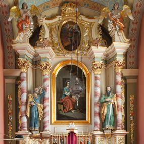 Zdjęcie nr 1: Nastawa ołtarzowa architektoniczna, jednoosiowa, jednokondygnacyjna ze zwieńczeniem, na podwójnym cokole. Ołtarz drewniany, prostopadłościenny; mensa drewniana z kamiennym portatylem. Antepedium podzielone na trzy pola czterema półkolumnami o stylizowanych kapitelach. W polach płyciny; w środkowej romb z płaskorzeźbionym kielichem z hostią; w zewnętrznych winne grona z kłosami zbóż.Tabernakulum w formie drewnianej skrzynki obitej blachą. Drzwiczki w kształcie stojącego prostokąta z aplikowaną, odlewaną plakietką ze sceną modlitwy Chrystusa w Ogrójcu, w narożach aplikowane uskrzydlone główki anielskie, całość w opasce dekorowanej różami. Tabernakulum w drewnianej obudowie, ściana frontowa flankowana parą kolumn. Tron wystawienia w formie niszy ujętej kolumienkami z łukiem o fantazyjnym wykroju. Całość zwieńczona rzeźbioną figurką Baranka Eucharystycznego leżącego na księdze. Po bokach tabernakulum stoją dwie pary nisz na postumentach z figurami czterech ewangelistów. Kondygnacja nastawy ujęta dwiema parami kolumn o kapitelach kompozytowych, stojących na tle zwielokrotnionych pilastrów. Podpory dźwigają fragmenty wyłamanego belkowania, zewnętrzna para również przerwany, wklęsło-wypukły przyczółek. Cokoły ustawione delikatnie pod kątem, zwrócone na zewnątrz. Na gzymsie wewnętrznych podpór niewielkie figurki puttów; na przyczółkach figury siedzących aniołów ubranych w długie suknie, okryte czerwonymi płaszczami. Między kolumnami na wspornikach figury św. Piotra i św. Pawła. W polu środkowym obraz św. Aleksego w profilowanej ramie w kształcie stojącego prostokąta zamkniętego łukiem półkolistym nadwieszonym. Zwieńczenie w formie leżącego prostokąta, ujętego masywnymi spływami wolutowymi, zamkniętego przeciwstawnie zwróconymi esownicami. W polu obraz św. Michała Archanioła w profilowanej ramie w formie stojącego owalu. Dolne partie cokołu dekorowane płaskorzeźbionym, stylizowanym akantem o układzie geometrycznym; wyższe z ornamentem w płycinach. Kondygnacja ujęta uszakami utworzonymi z karbowanej wstęgi przeplatającej się z ornamentem roślinnym. Woluty zwieńczenia dekorowane liśćmi palmowymi i kampanullami. Obraz w polu ujęty muszlami i liśćmi palmowymi; całość zwieńczona muszlą. Struktura polichromowana w odcieniu bieli; płyciny i fryz polichromowane na seledynowo, profile w odcieniu jasnego różu; trzony kolumn marmoryzowane; ornamentyka, kapitele, profile i ornamenty złocone i srebrzone.