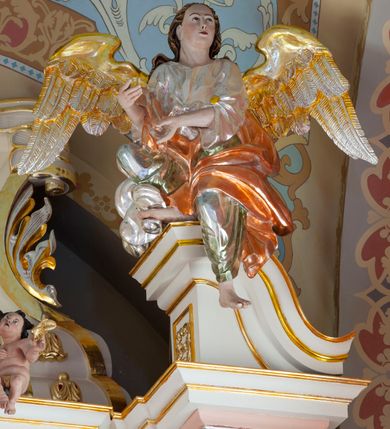 Zdjęcie nr 16: Nastawa ołtarzowa architektoniczna, jednoosiowa, jednokondygnacyjna ze zwieńczeniem, na podwójnym cokole. Ołtarz drewniany, prostopadłościenny; mensa drewniana z kamiennym portatylem. Antepedium podzielone na trzy pola czterema półkolumnami o stylizowanych kapitelach. W polach płyciny; w środkowej romb z płaskorzeźbionym kielichem z hostią; w zewnętrznych winne grona z kłosami zbóż.Tabernakulum w formie drewnianej skrzynki obitej blachą. Drzwiczki w kształcie stojącego prostokąta z aplikowaną, odlewaną plakietką ze sceną modlitwy Chrystusa w Ogrójcu, w narożach aplikowane uskrzydlone główki anielskie, całość w opasce dekorowanej różami. Tabernakulum w drewnianej obudowie, ściana frontowa flankowana parą kolumn. Tron wystawienia w formie niszy ujętej kolumienkami z łukiem o fantazyjnym wykroju. Całość zwieńczona rzeźbioną figurką Baranka Eucharystycznego leżącego na księdze. Po bokach tabernakulum stoją dwie pary nisz na postumentach z figurami czterech ewangelistów. Kondygnacja nastawy ujęta dwiema parami kolumn o kapitelach kompozytowych, stojących na tle zwielokrotnionych pilastrów. Podpory dźwigają fragmenty wyłamanego belkowania, zewnętrzna para również przerwany, wklęsło-wypukły przyczółek. Cokoły ustawione delikatnie pod kątem, zwrócone na zewnątrz. Na gzymsie wewnętrznych podpór niewielkie figurki puttów; na przyczółkach figury siedzących aniołów ubranych w długie suknie, okryte czerwonymi płaszczami. Między kolumnami na wspornikach figury św. Piotra i św. Pawła. W polu środkowym obraz św. Aleksego w profilowanej ramie w kształcie stojącego prostokąta zamkniętego łukiem półkolistym nadwieszonym. Zwieńczenie w formie leżącego prostokąta, ujętego masywnymi spływami wolutowymi, zamkniętego przeciwstawnie zwróconymi esownicami. W polu obraz św. Michała Archanioła w profilowanej ramie w formie stojącego owalu. Dolne partie cokołu dekorowane płaskorzeźbionym, stylizowanym akantem o układzie geometrycznym; wyższe z ornamentem w płycinach. Kondygnacja ujęta uszakami utworzonymi z karbowanej wstęgi przeplatającej się z ornamentem roślinnym. Woluty zwieńczenia dekorowane liśćmi palmowymi i kampanullami. Obraz w polu ujęty muszlami i liśćmi palmowymi; całość zwieńczona muszlą. Struktura polichromowana w odcieniu bieli; płyciny i fryz polichromowane na seledynowo, profile w odcieniu jasnego różu; trzony kolumn marmoryzowane; ornamentyka, kapitele, profile i ornamenty złocone i srebrzone.