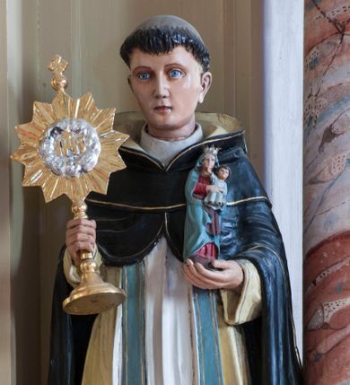 Zdjęcie nr 1: Rzeźba drążona z tyłu przedstawiająca stojącą na niewysokim, prostopadłościennym cokole postać św. Jacka Odrowąża. Święty jest ustawiony frontalnie, w lekkim kontrapoście, z prawym kolanem zgiętym. Twarz ma owalną, o delikatnych, młodzieńczych rysach, z jasnymi oczami, wąskim nosem i niewielkimi ustami; na głowie wycięta tonsura. Jest ubrany w strój dominikański: biały habit ze szkaplerzem i czarny płaszcz z kapturem, pod nim ma błękitną stułę. W lewej dłoni trzyma figurkę Madonny z Dzieciątkiem, w prawej monstrancję. Polichromia w partiach ciała naturalistyczna.