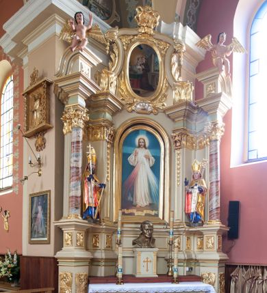 Zdjęcie nr 1: Nastawa ołtarzowa architektoniczna, jednoosiowa, jednokondygnacyjna ze zwieńczeniem, na potrójnym cokole. Ołtarz drewniany, prostopadłościenny; mensa drewniana z kamiennym portatylem. Antepedium zdobione polichromowanym monogramem IHS ujętym dekoracją roślinną. Tabernakulum prostopadłościenne, na cokole, zwieńczone gzymsem. Na ściance frontowej flankowanej pilastrami, drzwiczki w kształcie stojącego prostokąta zamkniętego łukiem półkolistym, dekorowane krzyżem o ramionach zakończonych trójlistnie. Kondygnacja nastawy ujęta parą pilastrów i kolumn o kapitelach kompozytowych, stojących na tle zwielokrotnionych pilastrów. Podpory dźwigają fragmenty wyłamanego belkowania, zewnętrzna para również przerwany, wklęsło-wypukły przyczółek. Cokoły ustawione delikatnie pod kątem, zwrócone na zewnątrz. Na gzymsie zewnętrznych podpór niewielkie figurki puttów. Między kolumnami a pilastrami, na wspornikach figury św. Stanisława i św. Wojciecha. W polu środkowym obraz „Jezu Ufam Tobie” w profilowanej ramie w kształcie stojącego prostokąta zamkniętego łukiem półkolistym. Zwieńczenie w formie stojącego prostokąta o wklęsłych bokach, ujętego spływami wolutowymi. W polu obraz św. Antoniego w profilowanej ramie w kształcie stojącego owalu. Dolne partie cokołu dekorowane płaskorzeźbionym, stylizowanym akantem o układzie geometrycznym; wyższy z ornamentem w płycinach. Na ściankach filarów kampanule, woluty zwieńczenia dekorowane liśćmi palmowymi i kampanulami. Obraz w polu ujęty liśćmi palmowymi i karbowaną wstążką, od dołu i góry muszlami. Struktura polichromowana w odcieniu bieli; płyciny i fryz polichromowane na seledynowo, profile w odcieniu beżowym; trzony kolumn marmoryzowane; ornamentyka, kapitele, profile i ornamenty złocone i srebrzone. 