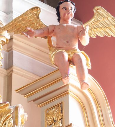 Zdjęcie nr 7: Nastawa ołtarzowa architektoniczna, jednoosiowa, jednokondygnacyjna ze zwieńczeniem, na potrójnym cokole. Ołtarz drewniany, prostopadłościenny; mensa drewniana z kamiennym portatylem. Antepedium zdobione polichromowanym monogramem IHS ujętym dekoracją roślinną. Tabernakulum prostopadłościenne, na cokole, zwieńczone gzymsem. Na ściance frontowej flankowanej pilastrami, drzwiczki w kształcie stojącego prostokąta zamkniętego łukiem półkolistym, dekorowane krzyżem o ramionach zakończonych trójlistnie. Kondygnacja nastawy ujęta parą pilastrów i kolumn o kapitelach kompozytowych, stojących na tle zwielokrotnionych pilastrów. Podpory dźwigają fragmenty wyłamanego belkowania, zewnętrzna para również przerwany, wklęsło-wypukły przyczółek. Cokoły ustawione delikatnie pod kątem, zwrócone na zewnątrz. Na gzymsie zewnętrznych podpór niewielkie figurki puttów. Między kolumnami a pilastrami, na wspornikach figury św. Stanisława i św. Wojciecha. W polu środkowym obraz „Jezu Ufam Tobie” w profilowanej ramie w kształcie stojącego prostokąta zamkniętego łukiem półkolistym. Zwieńczenie w formie stojącego prostokąta o wklęsłych bokach, ujętego spływami wolutowymi. W polu obraz św. Antoniego w profilowanej ramie w kształcie stojącego owalu. Dolne partie cokołu dekorowane płaskorzeźbionym, stylizowanym akantem o układzie geometrycznym; wyższy z ornamentem w płycinach. Na ściankach filarów kampanule, woluty zwieńczenia dekorowane liśćmi palmowymi i kampanulami. Obraz w polu ujęty liśćmi palmowymi i karbowaną wstążką, od dołu i góry muszlami. Struktura polichromowana w odcieniu bieli; płyciny i fryz polichromowane na seledynowo, profile w odcieniu beżowym; trzony kolumn marmoryzowane; ornamentyka, kapitele, profile i ornamenty złocone i srebrzone. 