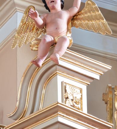 Zdjęcie nr 6: Nastawa ołtarzowa architektoniczna, jednoosiowa, jednokondygnacyjna ze zwieńczeniem, na potrójnym cokole. Ołtarz drewniany, prostopadłościenny; mensa drewniana z kamiennym portatylem. Antepedium zdobione polichromowanym monogramem IHS ujętym dekoracją roślinną. Tabernakulum prostopadłościenne, na cokole, zwieńczone gzymsem. Na ściance frontowej flankowanej pilastrami, drzwiczki w kształcie stojącego prostokąta zamkniętego łukiem półkolistym, dekorowane krzyżem o ramionach zakończonych trójlistnie. Kondygnacja nastawy ujęta parą pilastrów i kolumn o kapitelach kompozytowych, stojących na tle zwielokrotnionych pilastrów. Podpory dźwigają fragmenty wyłamanego belkowania, zewnętrzna para również przerwany, wklęsło-wypukły przyczółek. Cokoły ustawione delikatnie pod kątem, zwrócone na zewnątrz. Na gzymsie zewnętrznych podpór niewielkie figurki puttów. Między kolumnami a pilastrami, na wspornikach figury św. Stanisława i św. Wojciecha. W polu środkowym obraz „Jezu Ufam Tobie” w profilowanej ramie w kształcie stojącego prostokąta zamkniętego łukiem półkolistym. Zwieńczenie w formie stojącego prostokąta o wklęsłych bokach, ujętego spływami wolutowymi. W polu obraz św. Antoniego w profilowanej ramie w kształcie stojącego owalu. Dolne partie cokołu dekorowane płaskorzeźbionym, stylizowanym akantem o układzie geometrycznym; wyższy z ornamentem w płycinach. Na ściankach filarów kampanule, woluty zwieńczenia dekorowane liśćmi palmowymi i kampanulami. Obraz w polu ujęty liśćmi palmowymi i karbowaną wstążką, od dołu i góry muszlami. Struktura polichromowana w odcieniu bieli; płyciny i fryz polichromowane na seledynowo, profile w odcieniu beżowym; trzony kolumn marmoryzowane; ornamentyka, kapitele, profile i ornamenty złocone i srebrzone. 