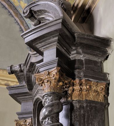 Zdjęcie nr 10: Ołtarz prostopadłościenny, w typie tumbowym, z mensą o brzegu zdobionym rzędem liści akantu naprzemian z łukami kotarowymi zwieńczonymi kulami oraz podwieszonym lambrekinem. Nastawa ołtarzowa jest architektoniczna, jednoosiowa ze zwieńczeniem, ujęta przez kolumny stojące na ukośnie dostawionych cokołach. Kolumny w jednej trzeciej kanelowane w dwóch trzecich skręcone z wplecioną wicią roślinną, ze złoconym kapitelem podtrzymują przerwany przyczółek ze ślimacznicami. Belkowanie bogato profilowane nad częścią środkową jest wyłamane trzema wklęsłymi łukami. W szczycie owalny medalion z monogramem ”MARIA”, w obramieniu z wieńca laurowego, ślimacznic i festonów, zakończony krzyżem. W osi środkowej prostokątna wnęka w profilowanym obramieniu, zamknięta półkolistym łukiem nadwieszonym z obrazem Matki Boskiej z Dzieciątkiem. 