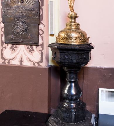 Zdjęcie nr 2: Podstawa na rzucie ośmioboku, dwuczęściowa, dolna część szeroka i niska o fazowanych krawędziach, górna wysoka i wąska. Trzon gładki, gruszkowaty, ujęty dwoma pierścieniami. Czara w dolnej części półkulista i gładka, w górnej ośmioboczna, zdobiona wgłębnymi ślepymi maswerkami, zakończona wydatnym, profilowanym gzymsem. Pokrywa metalowa, pozłacana. Brzeg w formie korony, zdobiony maswerkami oraz koronką w formie przestylizowanych lilii. Czasza półkulista zdobiona łuskami, zwieńczona cylindrycznym postumentem z dolną częścią zdobioną maswerkami, środkową w kształcie gładkiej wklęski i i górną, profilowaną z niewielką koronką. Na nim, na ośmiobocznym cokoliku, pełnoplastyczna postać św. Jana Chrzciciela z krzyżem w lewej ręce i barankiem leżącym na księdze w prawej. Jego twarz jest pociągła, święty spogląda w dół, ma długie włosy, opadające na plecy i ramiona. Jest ubrany w wielbłądzią skórę i płaszcz zarzucony na prawym ramieniu. 