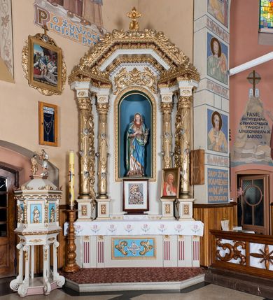 Zdjęcie nr 1: Nastawa ołtarzowa architektoniczna, jednoosiowa, jednokondygnacyjna ze zwieńczeniem. Ołtarz drewniany, prostopadłościenny. Mensa prostopadłościenna, z antepedium dekorowanym płyciną w kształcie leżącego prostokąta z krzyżem greckim o ramionach zakończonych rombami, na tle rombu i ujętym liśćmi. Flankują ją z każdej strony trzy pilastry o żłobkowanych trzonach. Na mensie, na cokole obraz z przedstawieniem Matki Boskiej Kalwaryjskiej. Nastawa ujęta parami kolumn na cokołach, z których zewnętrzne są wysunięte. Podpory dźwigają pełne belkowanie, którego architraw i fryz tworzą zygzak, a gzyms jest prosty. Na nich wspierają się trzy równoległe, załamane przyczółki zakomponowane uskokowo. Szczyt tworzy krzyż łaciński stylizowany na kwiat osadzony na łodydze z liśćmi. Pole środkowe ujęte profilowaną ramą z półokrągłą niszą wypełnioną figurą Najświętszego Serca Marii. Cokoły kolumn dekorowane płycinami z plakietami roślinnymi, trzony kolumn uskrzydlonymi główkami anielskimi podtrzymującymi festony utworzone z tkaniny i chwosty, między kolumnami ażurowa wić akantowa. Belkowanie ozdabia kostkowanie i astragal, pole nad obrazem wypełnia symetryczna wić akantowa, która wieńczy również gzyms belkowania i zewnętrzną krawędź przyczółków. Gzyms od spodu dekorowany rozetami. Struktura polichromowana na biało i jasnoszaro, kolumny, ornamenty i dekoracje złocone, płyciny czerwone i niebieskie; fragmenty baz kolumn zielone; nisza niebieska. 