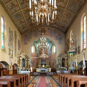Zdjęcie nr 1: Nastawa ołtarzowa architektoniczna, jednoosiowa, jednokondygnacyjna ze zwieńczeniem. Ołtarz drewniany, prostopadłościenny. Mensa drewniana, o silnie wysuniętym gzymsie dekorowanego kostkowaniem. Antepedium w formie leżącego prostokąta z płyciną o dwóch wypukłych bokach. W polu płaskorzeźbione przedstawienie pelikana karmiącego w gnieździe młode, flankowanego winnym gronem i kłosami zbóż; płycina ujęta parą uskrzydlonych główek anielskich. Antepedium zamknięte profilowanym gzymsem, dekorowanym kostkowaniem, dźwigającym niepełne belkowanie. Tabernakulum prostopadłościenne, w formie drewnianej skrzynki obitej blachą miedzianą, ustawione na wysokim cokole ujętym od frontu i po bokach spływami wolutowymi, dźwigającymi wyłamany gzyms dekorowany kostkowaniem; na froncie płycina z rozetą. Drzwiczki w kształcie leżącego prostokąta zamkniętego łukiem segmentowym z aplikowanym kielichem z hostią, w otoczeniu winnego grona, na fakturowanym tle. Tabernakulum flankowane parą kanelowanych kolumienek, dźwigających gzyms wieńczący, dekorowany kostkowaniem oraz szczyt w formie zbliżonej do trójkąta, zamknięty gzymsem przechodzącym w przeciwstawnie zwrócone woluty, dekorowane kostkowaniem; w polu uskrzydlona główka anielska. 
Retabulum na zryzalitowanym przy brzegach cokole; ujęte dwiema parami kolumn o kapitelach kompozytowych i kanelowanych trzonach dźwigających pełne belkowanie oraz trójkątny przyczółek trójbocznie załamany; na nim, na osi podpór przerwany, wolutowy przyczółek, z leżącymi nań figurami. Szczyt w postaci dwustrefowego cokołu ujętego kartuszem z figurą św. Michała Archanioła. Pole środkowe w całości wypełnia płytka nisza ujęta profilowaną ramą z obrazem „Trójca Święta”, wymiennie z przedstawieniami Matki Boskiej z Dzieciątkiem i św. Katarzyny. Kondygnację flankują, ustawione na cokołach figury św. Stanisława i św. Wojciecha. Cokoły kolumn dekorowane płycinami z uskrzydlonymi główkami anielskimi; w polu cokołu płycina w formie wydłużonego, leżącego prostokąta o wypukłych bokach, z dekoracją schweifwerkową. Trzony kolumn dekorowane uskrzydlonymi główkami anielskimi podtrzymującymi festony utworzone z tkaniny i chwosty. Za kolumnami płyciny wypełnione schweifwerkiem, w ich centrum obelisk dekorowany cekinami i zwieńczony krzyżem. W partii fryzu od frontu uskrzydlone główki anielskie, po bokach schweifwerk. Pola obu przyczółków wypełnia ornament schweifwerkowy. Gzyms od spodu dekorowany rozetami; zwieńczony wolutowym kluczem dekorowanym schwrifwerkiem oraz uskrzydloną główką anielską. Woluty wieńczące zdobione palmetami. Kondygnacja ujęta uszami utworzonymi z ornamentu okuciowego i ulistnionych wolut. Struktura w całości złocona, płyciny i profile polichromowane na czerwono, uszaki na zielono. 