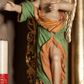 Zdjęcie nr 1: Rzeźba ścięta z tyłu, drążona, ustawiona na rzeźbionym, posrebrzanym obłoku. Figura anioła ukazana frontalnie, z lewą nogą opartą na obłoku oraz wyciągniętymi przed siebie, ugiętymi rękoma. Twarz ma owalną, o pełnych policzkach i podkreślonej brodzie, migdałowatych, opadających oczach, małym nosie i ustach, okoloną krótkimi, falowanymi, zaczesanymi w tył włosami. Anioł ubrany jest w obficie fałdowaną zieloną tunikę z pomarańczową podszewką, z jednym rękawem na prawym ramieniu, odsłaniającą tors, lewe ramię oraz lewą nogę. Skrzydła pozłacane, złożone po bokach postaci. Polichromia ciała naturalistyczna. 
