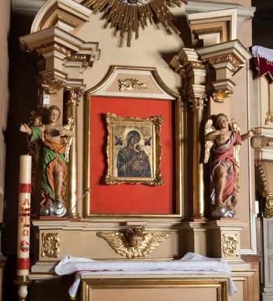 Zdjęcie nr 1: Nastawa architektoniczna, jednoosiowa, jednokondygnacyjna ze zwieńczeniem, ustawiona na wysokim dwustrefowym cokole. Ołtarz drewniany, prostopadłościenny z drewnianą mensą i kamiennym portatylem. Antepedium ujęte profilowaną ramą, w polu medalion z literą alfa. Retabulum ujęte dwiema parami pilastrów, przed wewnętrzną stoi para kolumn o kapitelach korynckich, przed zewnętrzną znajdują się figury aniołów. Podpory dźwigają pełne belkowanie, przerwane nad polem środkowym, nad figurami ustawione pod kątem imposty podtrzymywane przez muszle, dźwigające przerwany półkolisty przyczółek. Niemal całe pole środkowe wypełnia płycina w formie stojącego prostokąta o wklęsłych górnych narożach z dużo mniejszym obrazem Matki Boskiej Nieustającej Pomocy w osobnej ramie na czerwonym tle. Górna część płyciny dekorowana ornamentem roślinnym, u dołu, w partii predelli uskrzydlona główka anielska. Kondygnacja flankowana uszami utworzonymi z wolutowo skręconej wici roślinnej. Zwieńczenie w formie trapezu wypełnione niemal w całości owalnym medalionem z obrazem „Nawiedzenie św. Elżbiety”, ujętym otokiem z obłoków z uskrzydlonymi główkami anielskimi, w glorii promienistej. Struktura ołtarza polichromowana w kolorze beżowym, ornamentyka, profile i gloria pozłacane.