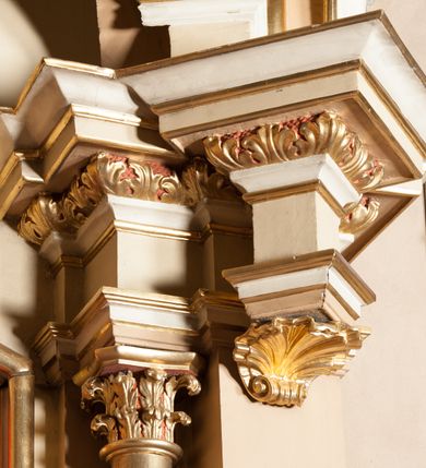 Zdjęcie nr 5: Nastawa architektoniczna, jednoosiowa, jednokondygnacyjna ze zwieńczeniem, ustawiona na wysokim dwustrefowym cokole. Ołtarz drewniany, prostopadłościenny z drewnianą mensą i kamiennym portatylem. Antepedium ujęte profilowaną ramą, w polu medalion z literą alfa. Retabulum ujęte dwiema parami pilastrów, przed wewnętrzną stoi para kolumn o kapitelach korynckich, przed zewnętrzną znajdują się figury aniołów. Podpory dźwigają pełne belkowanie, przerwane nad polem środkowym, nad figurami ustawione pod kątem imposty podtrzymywane przez muszle, dźwigające przerwany półkolisty przyczółek. Niemal całe pole środkowe wypełnia płycina w formie stojącego prostokąta o wklęsłych górnych narożach z dużo mniejszym obrazem Matki Boskiej Nieustającej Pomocy w osobnej ramie na czerwonym tle. Górna część płyciny dekorowana ornamentem roślinnym, u dołu, w partii predelli uskrzydlona główka anielska. Kondygnacja flankowana uszami utworzonymi z wolutowo skręconej wici roślinnej. Zwieńczenie w formie trapezu wypełnione niemal w całości owalnym medalionem z obrazem „Nawiedzenie św. Elżbiety”, ujętym otokiem z obłoków z uskrzydlonymi główkami anielskimi, w glorii promienistej. Struktura ołtarza polichromowana w kolorze beżowym, ornamentyka, profile i gloria pozłacane.