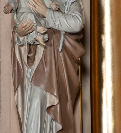 Zdjęcie nr 6: Nastawa architektoniczna, jednoosiowa, jednokondygnacyjna ze zwieńczeniem, ustawiona na wysokim dwustrefowym cokole. Ołtarz drewniany, prostopadłościenny z drewnianą mensą i kamiennym portatylem. Antepedium ujęte profilowaną ramą, w polu medalion z literą omega. Retabulum ujęte dwiema parami pilastrów, przed wewnętrzną stoi para kolumn o kapitelach korynckich. Zewnętrzne pilastry zdwojone, z kanelowanym trzonem, przed nimi znajdują się figury św. Józefa z Dzieciątkiem i św. Antoniego Padewskiego z Dzieciątkiem. Podpory dźwigają pełne belkowanie, dekorowane w partii fryzu ornamentem roślinnym. Nad figurami ustawione pod kątem imposty podtrzymywane przez wazonowate wsporniki, dźwigające przerwany półkolisty przyczółek. Całe pole środkowe wypełnia płycina w formie stojącego prostokąta z obrazem św. Franciszka, podtrzymywana u dołu przez wspornik. Zwieńczenie w formie trapezu wypełnione niemal w całości owalnym medalionem z obrazem św. Antoniego Padewskiego z Dzieciątkiem i Matką Boską, ujętym otokiem z obłoków z uskrzydlonymi główkami anielskimi w glorii promienistej. Struktura ołtarza polichromowana w kolorze beżowym, ornamentyka, profile i gloria pozłacane.