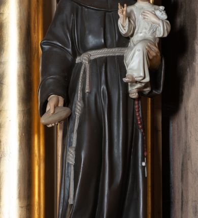 Zdjęcie nr 7: Nastawa architektoniczna, jednoosiowa, jednokondygnacyjna ze zwieńczeniem, ustawiona na wysokim dwustrefowym cokole. Ołtarz drewniany, prostopadłościenny z drewnianą mensą i kamiennym portatylem. Antepedium ujęte profilowaną ramą, w polu medalion z literą omega. Retabulum ujęte dwiema parami pilastrów, przed wewnętrzną stoi para kolumn o kapitelach korynckich. Zewnętrzne pilastry zdwojone, z kanelowanym trzonem, przed nimi znajdują się figury św. Józefa z Dzieciątkiem i św. Antoniego Padewskiego z Dzieciątkiem. Podpory dźwigają pełne belkowanie, dekorowane w partii fryzu ornamentem roślinnym. Nad figurami ustawione pod kątem imposty podtrzymywane przez wazonowate wsporniki, dźwigające przerwany półkolisty przyczółek. Całe pole środkowe wypełnia płycina w formie stojącego prostokąta z obrazem św. Franciszka, podtrzymywana u dołu przez wspornik. Zwieńczenie w formie trapezu wypełnione niemal w całości owalnym medalionem z obrazem św. Antoniego Padewskiego z Dzieciątkiem i Matką Boską, ujętym otokiem z obłoków z uskrzydlonymi główkami anielskimi w glorii promienistej. Struktura ołtarza polichromowana w kolorze beżowym, ornamentyka, profile i gloria pozłacane.