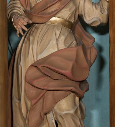 Zdjęcie nr 11: Nastawa architektoniczna, jednoosiowa, jednokondygnacyjna, ustawiona na wysokim cokole. Ołtarz w formie prostopadłościanu o ściętych z przodu narożach z prostokątną, drewnianą mensą, dekorowany trzema płycinami, na froncie monogram Marii ujęty winnym gronem. Na ołtarzu tabernakulum w formie prostopadłościennej skrzynki o ściętych przednich narożach, flankowanej parą pilastrów podtrzymujących gzyms. Drzwiczki w formie stojącego prostokąta zamkniętego półkoliście, ujęte profilowaną ramą, w polu płaskorzeźbiony kielich z hostią. 
Nastawa flankowana parą zwróconych na zewnątrz zdwojonych pilastrów i stojącą przed nimi parą kolumn o kapitelach kompozytowych. Podpory dźwigają pełne belkowanie z wyłamanym nad polem środkowym na kształt łuku odcinkowego gzymsem oraz przerwany, półkolisty przyczółek. Po zewnętrznej stronie kolumn dwie konsole, na których stoją figury św. Anny i św. Joachima. W polu głównym nisza w formie stojącego prostokąta zamkniętego łukiem półkolistym nadwieszonym z uskokiem, ujęta profilowaną ramą, dekorowana rocaille&#039;em, wewnątrz mniejszy obraz Matki Boskiej z Dzieciątkiem w kształcie stojącego prostokąta. W przyłuczach niszy dwie ukwiecone gałązki, na gzymsie uskrzydlona główka anielska, u dołu rocaille&#039;owy kartusz. W miejscu zwieńczenia, na tle okna zamontowany medalion z monogramem Marii w glorii promienistej. Struktura polichromowana w kolorze jasnoniebieskim z beżowymi detalami, ornamentyka, kolumny i profile pozłocone. 