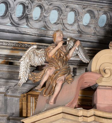 Zdjęcie nr 8: Ołtarz kamienny, prostopadłościenny, z kamienną mensą oraz antepedium w formie leżącego prostokąta z tkaniny, ujętym profilowaną, drewnianą i złoconą ramą. Na ołtarzu ustawione tabernakulum z tronem wystawienia. 
Nastawa architektoniczna, jednoosiowa, jednokondygnacyjna ze zwieńczeniem, ustawiona na dwustrefowym cokole ze skrajnie wyłamanymi pod kątem trzema parami prostopadłościanów. Retabulum ujęte ustawionymi pod kątem na zewnątrz filarami, opilastrowanymi po wewnętrznej stronie oraz stojącą przed nimi parą kolumn o kapitelach kompozytowych. Na skrajnie wyłamanych fragmentach cokołu ustawione figury świętego biskupa i świętego papieża. Podpory dźwigają pełne belkowanie połączone nad polem głównym wyłącznie gzymsem wyłamanym na kształt łuku odcinkowego nadwieszonego. Na osi kolumn, na belkowaniu fragmenty przerwanego falistego przyczółka, skierowane do wewnątrz, na których znajdują się dwie figury siedzących aniołów. W polu głównym wnęka w formie stojącego prostokąta zamkniętego łukiem półkolistym nadwieszonym z uskokiem, ujęta profilowaną ramą dekorowaną rocaille'm. W niej zamontowany obraz Trójcy Świętej ze św. Franciszkiem i św. Dominikiem. Ponad wnęką rokokowy kartusz z napisem w polu: „S[anctus] S[anctus] S[anctus]”. Po bokach wnęki dwa pola w kształcie rombów o ściętych kątach z wprawionymi lustrami. Zwieńczenie w formie zbliżonej do trapezu ujętego spływami wolutowymi, zamkniętego fragmentem falistego gzymsu, dekorowane z trzech stron rocaille'm. W polu zwieńczenia płycina o tej samej formie, wewnątrz obraz św. Marii Magdaleny w kształcie zbliżonym do trapezu o ściętych dolnych narożach, ujęty profilowaną ramą dekorowaną rocaille'm. Struktura polichromowana w odcieniach beżu, partiami zaś różu i jasnej czerwieni; płyciny cokołu i trzony kolumn polichromowane na sposób imitujący marmoryzację w odcieniach zieleni, niektóre płyciny również czerwieni. Profile i ornamentyka złocone.
