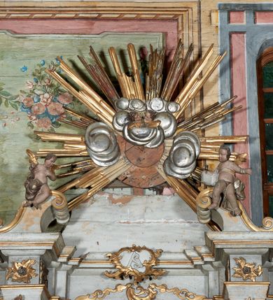 Zdjęcie nr 6: Mensa drewniana; ołtarz sarkofagowy, o wklęsłych bokach, zwężających się ku dołowi, ustawiony na niskim cokole zakończonym podwójnym półwałkiem, dekorowany rocaille'owym kartuszem. Ołtarz ustawiony na trzech drewnianych stopniach.
Retabulum jednoosiowe, jednokondygnacyjne, z niskim dwustrefowym cokołem z wyłamanymi dwoma sześcianami, stanowiącymi cokoły. Nastawa ołtarzowa ujęta parą kolumn kompozytowych ustawionych na tle zwielokrotnionych pilastrów. Podpory wspierają pełne belkowanie z wyłamanymi impostami na osi kolumn, na których znajdują się fragmenty wolutowego przerwanego przyczółka, na których siedzą dwa putta. Zwieńczenie ułamane, nad nim zamontowana gloria promienista z obłokami i dwiema uskrzydlonymi główkami anielskimi. W polu środkowym obraz w formie stojącego prostokąta z przedstawieniem Matki Boskiej z Dzieciątkiem. Nastawa dekorowana ornamentem o motywach roślinnych i cęgowych w partii cokołu, pilastrów i belkowania, na impostach dwie rozety. Retabulum ujęte uszami utworzonymi z ornamentu rocaille'owego i motywów roślinnych. Po bokach ołtarza dostawione cokoły, na których ustawione figury św. Wojciecha i św. Stanisława. Struktura nastawy polichromowana w kolorze białym, profile, kolumny, gloria i ornamentyka złocone.

