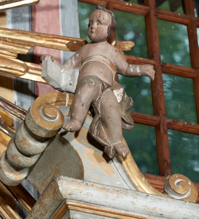 Zdjęcie nr 8: Mensa drewniana; ołtarz sarkofagowy, o wklęsłych bokach, zwężających się ku dołowi, ustawiony na niskim cokole zakończonym podwójnym półwałkiem, dekorowany rocaille'owym kartuszem. Ołtarz ustawiony na trzech drewnianych stopniach.
Retabulum jednoosiowe, jednokondygnacyjne, z niskim dwustrefowym cokołem z wyłamanymi dwoma sześcianami, stanowiącymi cokoły. Nastawa ołtarzowa ujęta parą kolumn kompozytowych ustawionych na tle zwielokrotnionych pilastrów. Podpory wspierają pełne belkowanie z wyłamanymi impostami na osi kolumn, na których znajdują się fragmenty wolutowego przerwanego przyczółka, na których siedzą dwa putta. Zwieńczenie ułamane, nad nim zamontowana gloria promienista z obłokami i dwiema uskrzydlonymi główkami anielskimi. W polu środkowym obraz w formie stojącego prostokąta z przedstawieniem Matki Boskiej z Dzieciątkiem. Nastawa dekorowana ornamentem o motywach roślinnych i cęgowych w partii cokołu, pilastrów i belkowania, na impostach dwie rozety. Retabulum ujęte uszami utworzonymi z ornamentu rocaille'owego i motywów roślinnych. Po bokach ołtarza dostawione cokoły, na których ustawione figury św. Wojciecha i św. Stanisława. Struktura nastawy polichromowana w kolorze białym, profile, kolumny, gloria i ornamentyka złocone.

