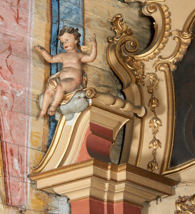 Zdjęcie nr 5: Nastawa ołtarzowa architektoniczna, ustawiona na jednym stopniu; jednoosiowa, jednokondygnacyjna ze zwieńczeniem, na wysokim cokole. Ołtarz drewniany, sarkofagowy, wklęsło-wypukły, zwężający się ku dołowi, zamknięty gzymsem, na cokole. Mensa drewniana. W polu antepedium rocaille&#039;owa płycina w formie odwróconego trapezu. 
Retabulum flankowane parą filarów ustawionych pod kątem na zewnątrz względem lica ołtarza; z pilastrami po wewnętrznej stronie, o kapitelach jońskich i kanelowanych trzonach. Podpory dźwigają imposty, od frontu podtrzymywane przez konsole oraz przerwany, wolutowy przyczółek, na którym siedzi para puttów. Przed filarami cokoły w formie wolut, flankujące ołtarz, z figurami św. Jakuba i św. Andrzeja. W polu środkowym rama w formie stojącego prostokąta zamkniętego stylizowanym łukiem nadwieszonym z uskokiem z obrazem św. Jana Nepomucena. Zwieńczenie w formie stojącego prostokąta, zamkniętego gzymsem przyjmującym kształt łuku segmentowego nadwieszonego; ujęte podwójnymi spływami wolutowymi, których ślimacznice tworzą uszaki. W polu rama w formie stojącego prostokąta o wklęsłych bokach, zamkniętego łukiem półkolistym z uskokiem, z obrazem św. Katarzyny.
Trzony filarów dekorowane festonami utworzonymi z rocaille&#039;u i ukwieconych gałązek. Rama obrazu pola środkowego zdobiona po bokach i u spodu fragmentami rocaille&#039;u, zwieńczona parą uskrzydlonych główek anielskich na obłoku. U spodu obrazu tron wystawienia w formie wspornika podtrzymywanego przez konsolę z rocaille&#039;m. Pole nad obrazem wypełnione rocaille&#039;owym kartuszem. Kondygnacja ujęta uszami utworzonymi z ażurowego rocaille&#039;u. Rama zwieńczenia dekorowana fragmentami rocaille&#039;u u spodu, w partii uskoków i na łuku; flankowana kampanulami. Woluty ujmujące zwieńczenie zdobione rocaille&#039;m. Gzyms wieńczący ze szczytem utworzonym z rocaille&#039;u, flankowany przez dwa rokokowe wazony na skraju. 
Struktura polichromowana w kolorze beżowym, detale na seledynowo i różowo; ornamentyka, profile, ramy i kanelury złocone.