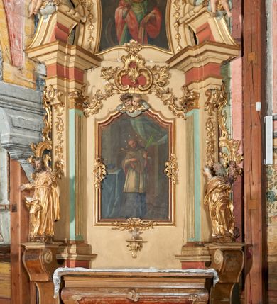 Zdjęcie nr 1: Nastawa ołtarzowa architektoniczna, ustawiona na jednym stopniu; jednoosiowa, jednokondygnacyjna ze zwieńczeniem, na wysokim cokole. Ołtarz drewniany, sarkofagowy, wklęsło-wypukły, zwężający się ku dołowi, zamknięty gzymsem, na cokole. Mensa drewniana. W polu antepedium rocaille'owa płycina w formie odwróconego trapezu. 
Retabulum flankowane parą filarów ustawionych pod kątem na zewnątrz względem lica ołtarza; z pilastrami po wewnętrznej stronie, o kapitelach jońskich i kanelowanych trzonach. Podpory dźwigają imposty, od frontu podtrzymywane przez konsole oraz przerwany, wolutowy przyczółek, na którym siedzi para puttów. Przed filarami cokoły w formie wolut, flankujące ołtarz, z figurami św. Jakuba i św. Andrzeja. W polu środkowym rama w formie stojącego prostokąta zamkniętego stylizowanym łukiem nadwieszonym z uskokiem z obrazem św. Jana Nepomucena. Zwieńczenie w formie stojącego prostokąta, zamkniętego gzymsem przyjmującym kształt łuku segmentowego nadwieszonego; ujęte podwójnymi spływami wolutowymi, których ślimacznice tworzą uszaki. W polu rama w formie stojącego prostokąta o wklęsłych bokach, zamkniętego łukiem półkolistym z uskokiem, z obrazem św. Katarzyny.
Trzony filarów dekorowane festonami utworzonymi z rocaille'u i ukwieconych gałązek. Rama obrazu pola środkowego zdobiona po bokach i u spodu fragmentami rocaille'u, zwieńczona parą uskrzydlonych główek anielskich na obłoku. U spodu obrazu tron wystawienia w formie wspornika podtrzymywanego przez konsolę z rocaille'm. Pole nad obrazem wypełnione rocaille'owym kartuszem. Kondygnacja ujęta uszami utworzonymi z ażurowego rocaille'u. Rama zwieńczenia dekorowana fragmentami rocaille'u u spodu, w partii uskoków i na łuku; flankowana kampanulami. Woluty ujmujące zwieńczenie zdobione rocaille'm. Gzyms wieńczący ze szczytem utworzonym z rocaille'u, flankowany przez dwa rokokowe wazony na skraju. 
Struktura polichromowana w kolorze beżowym, detale na seledynowo i różowo; ornamentyka, profile, ramy i kanelury złocone.