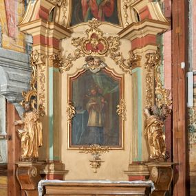 Zdjęcie nr 1: Nastawa ołtarzowa architektoniczna, ustawiona na jednym stopniu; jednoosiowa, jednokondygnacyjna ze zwieńczeniem, na wysokim cokole. Ołtarz drewniany, sarkofagowy, wklęsło-wypukły, zwężający się ku dołowi, zamknięty gzymsem, na cokole. Mensa drewniana. W polu antepedium rocaille&#039;owa płycina w formie odwróconego trapezu. 
Retabulum flankowane parą filarów ustawionych pod kątem na zewnątrz względem lica ołtarza; z pilastrami po wewnętrznej stronie, o kapitelach jońskich i kanelowanych trzonach. Podpory dźwigają imposty, od frontu podtrzymywane przez konsole oraz przerwany, wolutowy przyczółek, na którym siedzi para puttów. Przed filarami cokoły w formie wolut, flankujące ołtarz, z figurami św. Jakuba i św. Andrzeja. W polu środkowym rama w formie stojącego prostokąta zamkniętego stylizowanym łukiem nadwieszonym z uskokiem z obrazem św. Jana Nepomucena. Zwieńczenie w formie stojącego prostokąta, zamkniętego gzymsem przyjmującym kształt łuku segmentowego nadwieszonego; ujęte podwójnymi spływami wolutowymi, których ślimacznice tworzą uszaki. W polu rama w formie stojącego prostokąta o wklęsłych bokach, zamkniętego łukiem półkolistym z uskokiem, z obrazem św. Katarzyny.
Trzony filarów dekorowane festonami utworzonymi z rocaille&#039;u i ukwieconych gałązek. Rama obrazu pola środkowego zdobiona po bokach i u spodu fragmentami rocaille&#039;u, zwieńczona parą uskrzydlonych główek anielskich na obłoku. U spodu obrazu tron wystawienia w formie wspornika podtrzymywanego przez konsolę z rocaille&#039;m. Pole nad obrazem wypełnione rocaille&#039;owym kartuszem. Kondygnacja ujęta uszami utworzonymi z ażurowego rocaille&#039;u. Rama zwieńczenia dekorowana fragmentami rocaille&#039;u u spodu, w partii uskoków i na łuku; flankowana kampanulami. Woluty ujmujące zwieńczenie zdobione rocaille&#039;m. Gzyms wieńczący ze szczytem utworzonym z rocaille&#039;u, flankowany przez dwa rokokowe wazony na skraju. 
Struktura polichromowana w kolorze beżowym, detale na seledynowo i różowo; ornamentyka, profile, ramy i kanelury złocone.