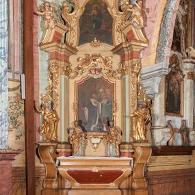 Zdjęcie nr 1: Nastawa ołtarzowa architektoniczna, ustawiona na trzech stopniach; jednoosiowa, jednokondygnacyjna ze zwieńczeniem, na wysokim cokole. Ołtarz drewniany, sarkofagowy, wklęsło-wypukły, zwężający się ku dołowi, zamknięty gzymsem, na cokole. Mensa drewniana. W polu antependium rocaille&#039;owa płycina w formie odwróconego trapezu.  
Retabulum flankowane parą filarów ustawionych pod kątem, na zewnątrz względem lica ołtarza; z pilastrami po wewnętrznej stronie, o kapitelach jońskich i kanelowanych trzonach. Podpory dźwigają imposty, od frontu podtrzymywane przez konsole oraz przerwany, wolutowy przyczółek, na którym siedzi para puttów. Przed filarami cokoły w formie wolut, flankujące ołtarz, z figurami św. Piotra i św. Pawła. W polu środkowym rama w formie stojącego prostokąta zamkniętego stylizowanym łukiem nadwieszonym z uskokiem z obrazem św. Jana Kantego. Zwieńczenie w formie stojącego prostokąta zamkniętego gzymsem przyjmującym kształt łuku segmentowego nadwieszonego; ujęte podwójnymi spływami wolutowymi, których ślimacznice tworzą uszaki. W polu rama w formie stojącego prostokąta o wklęsłych bokach, zamkniętego łukiem półkolistym z uskokiem, z obrazem Wniebowzięcia Najświętszej Marii Panny.
Trzony filarów dekorowane festonami utworzonymi z rocaille&#039;u i ukwieconych gałązek. Rama obrazu w polu środkowym zdobiona po bokach fragmentami rocaille&#039;u, zwieńczona parą uskrzydlonych główek anielskich na obłoku. U spodu obrazu tron wystawienia w formie wspornika podtrzymywanego przez konsolę z rocaille&#039;u. Pole nad obrazem wypełniają fragmenty rocaille&#039;u. Kondygnacja ujęta uszami utworzonymi z ażurowego rocaille&#039;u. Rama zwieńczenia dekorowana fragmentami rocaille u spodu, w partii uskoków i na łuku; flankowana kampanulami. Woluty ujmujące zwieńczenie zdobione rocaille&#039;m. Gzyms wieńczący ze szczytem utworzonym z palmet, flankowany przez dwa rokokowe wazony na skraju. 
Struktura polichromowana w kolorze beżowym, detale na seledynowo i czerwono; ornamentyka, profile, ramy i kanelury złocone.