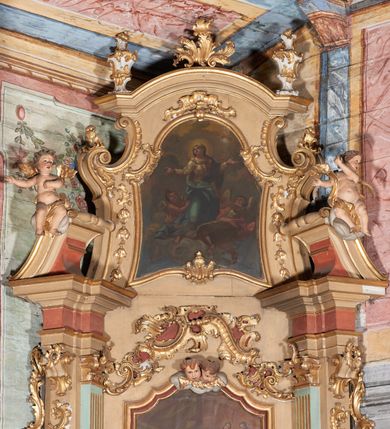 Zdjęcie nr 4: Nastawa ołtarzowa architektoniczna, ustawiona na trzech stopniach; jednoosiowa, jednokondygnacyjna ze zwieńczeniem, na wysokim cokole. Ołtarz drewniany, sarkofagowy, wklęsło-wypukły, zwężający się ku dołowi, zamknięty gzymsem, na cokole. Mensa drewniana. W polu antependium rocaille&#039;owa płycina w formie odwróconego trapezu.  
Retabulum flankowane parą filarów ustawionych pod kątem, na zewnątrz względem lica ołtarza; z pilastrami po wewnętrznej stronie, o kapitelach jońskich i kanelowanych trzonach. Podpory dźwigają imposty, od frontu podtrzymywane przez konsole oraz przerwany, wolutowy przyczółek, na którym siedzi para puttów. Przed filarami cokoły w formie wolut, flankujące ołtarz, z figurami św. Piotra i św. Pawła. W polu środkowym rama w formie stojącego prostokąta zamkniętego stylizowanym łukiem nadwieszonym z uskokiem z obrazem św. Jana Kantego. Zwieńczenie w formie stojącego prostokąta zamkniętego gzymsem przyjmującym kształt łuku segmentowego nadwieszonego; ujęte podwójnymi spływami wolutowymi, których ślimacznice tworzą uszaki. W polu rama w formie stojącego prostokąta o wklęsłych bokach, zamkniętego łukiem półkolistym z uskokiem, z obrazem Wniebowzięcia Najświętszej Marii Panny.
Trzony filarów dekorowane festonami utworzonymi z rocaille&#039;u i ukwieconych gałązek. Rama obrazu w polu środkowym zdobiona po bokach fragmentami rocaille&#039;u, zwieńczona parą uskrzydlonych główek anielskich na obłoku. U spodu obrazu tron wystawienia w formie wspornika podtrzymywanego przez konsolę z rocaille&#039;u. Pole nad obrazem wypełniają fragmenty rocaille&#039;u. Kondygnacja ujęta uszami utworzonymi z ażurowego rocaille&#039;u. Rama zwieńczenia dekorowana fragmentami rocaille u spodu, w partii uskoków i na łuku; flankowana kampanulami. Woluty ujmujące zwieńczenie zdobione rocaille&#039;m. Gzyms wieńczący ze szczytem utworzonym z palmet, flankowany przez dwa rokokowe wazony na skraju. 
Struktura polichromowana w kolorze beżowym, detale na seledynowo i czerwono; ornamentyka, profile, ramy i kanelury złocone.