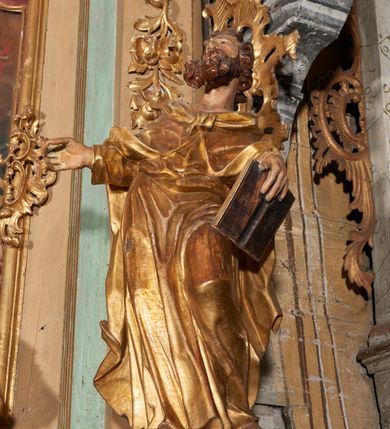 Zdjęcie nr 9: Nastawa ołtarzowa architektoniczna, ustawiona na trzech stopniach; jednoosiowa, jednokondygnacyjna ze zwieńczeniem, na wysokim cokole. Ołtarz drewniany, sarkofagowy, wklęsło-wypukły, zwężający się ku dołowi, zamknięty gzymsem, na cokole. Mensa drewniana. W polu antependium rocaille&#039;owa płycina w formie odwróconego trapezu.  
Retabulum flankowane parą filarów ustawionych pod kątem, na zewnątrz względem lica ołtarza; z pilastrami po wewnętrznej stronie, o kapitelach jońskich i kanelowanych trzonach. Podpory dźwigają imposty, od frontu podtrzymywane przez konsole oraz przerwany, wolutowy przyczółek, na którym siedzi para puttów. Przed filarami cokoły w formie wolut, flankujące ołtarz, z figurami św. Piotra i św. Pawła. W polu środkowym rama w formie stojącego prostokąta zamkniętego stylizowanym łukiem nadwieszonym z uskokiem z obrazem św. Jana Kantego. Zwieńczenie w formie stojącego prostokąta zamkniętego gzymsem przyjmującym kształt łuku segmentowego nadwieszonego; ujęte podwójnymi spływami wolutowymi, których ślimacznice tworzą uszaki. W polu rama w formie stojącego prostokąta o wklęsłych bokach, zamkniętego łukiem półkolistym z uskokiem, z obrazem Wniebowzięcia Najświętszej Marii Panny.
Trzony filarów dekorowane festonami utworzonymi z rocaille&#039;u i ukwieconych gałązek. Rama obrazu w polu środkowym zdobiona po bokach fragmentami rocaille&#039;u, zwieńczona parą uskrzydlonych główek anielskich na obłoku. U spodu obrazu tron wystawienia w formie wspornika podtrzymywanego przez konsolę z rocaille&#039;u. Pole nad obrazem wypełniają fragmenty rocaille&#039;u. Kondygnacja ujęta uszami utworzonymi z ażurowego rocaille&#039;u. Rama zwieńczenia dekorowana fragmentami rocaille u spodu, w partii uskoków i na łuku; flankowana kampanulami. Woluty ujmujące zwieńczenie zdobione rocaille&#039;m. Gzyms wieńczący ze szczytem utworzonym z palmet, flankowany przez dwa rokokowe wazony na skraju. 
Struktura polichromowana w kolorze beżowym, detale na seledynowo i czerwono; ornamentyka, profile, ramy i kanelury złocone.