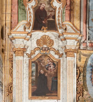 Zdjęcie nr 1: Retabulum podtrzymywane na drewnianej listwie w formie profilowanego wspornika. Nastawa architektoniczna, jednoosiowa, jednokondygnacyjna ze zwieńczeniem, ustawiona na niskim cokole. Retabulum ujęte parą zdwojonych pilastrów o kapitelach kompozytowych i kanelowanych trzonach, dźwigających zdwojone imposty oraz fragmenty przerwanego, falistego przyczółka. Na osi pilastrów ustawione konsole dekorowane rocaille&#039;owymi kartuszami. W polu głównym wnęka w formie stojącego prostokąta zamkniętego łukiem falistym z uskokiem, ujęta profilowaną ramą; z obrazem św. Stanisława Kostki. Rama dekorowana fragmentami ornamentu roślinnego, zwieńczona dwoma uskrzydlonymi główkami anielskimi na obłoku, ponad nimi rocaille ujęty dwoma ornamentalno-roślinnymi zwisami. Poniżej obrazu wspornik dekorowany perełkowaniem, cekinami i żłobkami. Nastawa ujęta uszami utworzonymi z rocaille&#039;u i ornamentu roślinnego. Zwieńczenie retabulum w formie zbliżonej do trapezu, o wklęsłych bokach z wolutowymi uszakami, zamknięte fragmentem gzymsu wyłamanym na kształt łuku odcinkowego nadwieszonego, dekorowane dwoma wazonikami oraz fragmentami rocaille&#039;u i zwisami kwiatowymi. W polu obraz św. Jana z Dukli w formie zbliżonej do zwieńczenia, ujęty wąską ramą dekorowaną rocaille&#039;m. Obraz flankowany kampanulami. Struktura polichromowana na sposób imitujący marmoryzację w kolorze biało-szarym, profile i ornamentyka złocone. Na listwie podtrzymującej nastawę ustawione dwie figury – św. Jana Ewangelisty i niezidentyfikowanego biskupa. 



