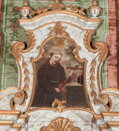 Zdjęcie nr 3: Retabulum podtrzymywane na drewnianej listwie w formie profilowanego wspornika. Nastawa architektoniczna, jednoosiowa, jednokondygnacyjna ze zwieńczeniem, ustawiona na niskim cokole. Retabulum ujęte parą zdwojonych pilastrów o kapitelach kompozytowych i kanelowanych trzonach, dźwigających zdwojone imposty oraz fragmenty przerwanego, falistego przyczółka. Na osi pilastrów ustawione konsole dekorowane rocaille'owymi kartuszami. W polu głównym wnęka w formie stojącego prostokąta zamkniętego łukiem falistym z uskokiem, ujęta profilowaną ramą; z obrazem św. Stanisława Kostki. Rama dekorowana fragmentami ornamentu roślinnego, zwieńczona dwoma uskrzydlonymi główkami anielskimi na obłoku, ponad nimi rocaille ujęty dwoma ornamentalno-roślinnymi zwisami. Poniżej obrazu wspornik dekorowany perełkowaniem, cekinami i żłobkami. Nastawa ujęta uszami utworzonymi z rocaille'u i ornamentu roślinnego. Zwieńczenie retabulum w formie zbliżonej do trapezu, o wklęsłych bokach z wolutowymi uszakami, zamknięte fragmentem gzymsu wyłamanym na kształt łuku odcinkowego nadwieszonego, dekorowane dwoma wazonikami oraz fragmentami rocaille'u i zwisami kwiatowymi. W polu obraz św. Jana z Dukli w formie zbliżonej do zwieńczenia, ujęty wąską ramą dekorowaną rocaille'm. Obraz flankowany kampanulami. Struktura polichromowana na sposób imitujący marmoryzację w kolorze biało-szarym, profile i ornamentyka złocone. Na listwie podtrzymującej nastawę ustawione dwie figury – św. Jana Ewangelisty i niezidentyfikowanego biskupa. 



