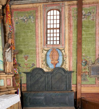 Zdjęcie nr 2: Drewniane stalle, jednorzędowe, na profilowanej podstawie. Przedpiersie dekorowane dwoma płycinami w formie leżącego prostokąta, zakończone profilowanym gzymsem. Zaplecek wysoki, dwuosiowy, wydzielony trzema pilastrami o kanelowanych trzonach dźwigających profilowany gzyms wyłamany na kształt łuku półkolistego nadwieszonego na każdej osi. W polach zaplecka płyciny w formie kwadratów zamkniętych łukami półkolistymi nadwieszonymi. Stalle polichromowane na sposób imitujący marmoryzację w kolorze szaro-niebieskim. 