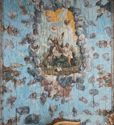 Zdjęcie nr 1: Ściany prezbiterium dekorowane malowanymi zielono-różowymi płycinami w formie stojących prostokątów, ujętymi iluzjonistycznymi ramkami, z malowaną dekoracją w formie kwiatowych festonów w górnej części oraz fantazyjnych dekoracji roślinno-kandelabrowych i wazonów z ornamentem roślinnym w dolnej. Płyciny umieszczone są między oknami ujętymi w malowane prostokątne opaski, pod którymi znajdują się zacheuszki. Na południowej ścianie znajdują się dwa okna, na północnej dwa pozorne okna, z których jedno przesłania ambona. Zacheuszki w formie malowanych migdałowatych medalionów z krzyżami w polach, na iluzjonistycznych wspornikach o klasycyzującej dekoracji, na tle niebieskich owalnych medalionów ujętych u góry wieńcem laurowym i u dołu dekoracją roślinną. Prezbiterium zamknięte trójbocznie, z podkreślonymi polichromią dwiema parami zwielokrotnionych pilastrów, flankujących ołtarz główny. Za ołtarzem, na każdej z trzech ścian analogicznie malowane płyciny. Dolny pas wszystkich ścian prezbiterium opasuje malowany iluzjonistycznie jasnobrązowy i marmoryzowany cokół, dekorowany płycinami w formie leżącego prostokąta i zamknięty profilowaniem. Ściany prezbiterium zamknięte od góry drewnianym gzymsem pokrytym malowanymi iluzjonistycznie elementami profili z kostkowaniem i jajownikiem.
Sklepienie w części prezbiterialnej w formie malowanego nieba, wypełnionego obłokami. Nad gzymsem malowana iluzjonistycznie kamienna balustrada z ośmioma wazonami na cokołach umieszczonych na osiach wydzielających podziały ścian prezbiterium, z motywem stylizowanego biegnącego psa stanowiącym wypełnienie balustrady. Pomiędzy wazonami ukazani jako stojący za balustradą i widoczni w półpostaci aniołowie. Na północnej ścianie anioł trzymający w dłoniach zamknięta koronę, z napisem „PRINCIPATUS” oraz anioł ubrany w zbroję i hełm z białą chorągwią w prawej ręce, podpisany „ARCHANGELI”. Na południowej ścianie anioł ubrany w suknię i płaszcz, który prawą ręką wskazuje niebo, lewą zaś tuli do siebie dziecko, podpisany „ANGELI” oraz anioł ubrany w suknię i płaszcz, który lewą rękę kładzie na piersi, w prawej trzyma miecz skierowany ostrzem w dół, podpisany „DOMINATIONES”. W centralnej części sklepienia ujęta obłokami z malowanym u dołu aniołem scena ekstazy św. Marii Magdaleny. Ukazuje ona omdlewającą na skałach świętą, której towarzyszą aniołowie. Maria Magdalena przedstawiona z profilu, jako siedząca, odchylona w tył, z opadającą głową i rękami. Ubrana w biało-niebieską suknię odsłaniającą ramiona. Włosy ma długie, opadające na plecy i pierś. Nad głową nimb. Za nią i obok niej siedzą dwaj aniołowie, który podtrzymują jej opadające ciało. Przy prawym boku świętej znajduje się krucyfiks, natomiast w dolnej części sceny, na ziemi leżą: czaszka, dyscyplina, otwarta księga i puszka na wonności. W górnej części sceny ukazane rozświetlone niebo, z którego wyłania się wiązka światła, a wokół ukazane są trzy uskrzydlone główki anielskie. Na ścianie zachodniej prezbiterium, nad łukiem tęczowym napis: „Roku Pańskiego 1565 kościół ten zbudowany przez wielmożnego Pana Spytka Jordana, poświęcony przez najjaśniejszego i przewielebnego Pana Tomasza Oborskiego, Biskupa Loadycejskiego, Syfragana Krakowskiego w Roku Pańskim 1634 w dniu 5 czerwca. Odnowiony całkowicie i ozdobiony ołtarzami wraz z organami i chórem przez plebana w Roku pańskim 1778. Odmalowany zaś kosztem tegoż plebana w Roku Pańskim 1802. A[ndrzej] A[ntałkiewicz]”. Za ołtarzem głównym drugi napis: „Restau/rata Hoc / Ecclesia / AD 1777 / Finita 23 / Septembris”.
W korpusie nawowym polichromia o analogicznej formie. Na ścianach północnej i południowej malowane płyciny pomiędzy oknami, okna w malowanych opaskach z zacheuszkami w formie medalionów poniżej. Ściana tęczowa zdobiona malowanymi płycinami, łuk ujęty malowanym en grisaille owocowo-kwiatowym festonem, opadającym na wsporniki z malowanymi iluzjonistycznie elementami architektonicznymi. Ściana zachodnia w dolnej partii malowana analogicznie do ścian bocznych. Natomiast w górnej partii, od poziomu parapetu chóru muzycznego malowana iluzjonistycznie architektura w postaci opilastrowanego muru kamiennego i arkady pośrodku z apsydą o podziałach pilastrowych z malowanymi oknami, na której tle umieszczony jest organ. Zaskrzynienia z malowanymi prostokątnymi płycinami. Filary podtrzymujące zaskrzynienia malowane na sposób imitujący marmoryzację. Podpory podtrzymujące drewniany profilowany gzyms pokryty malowanymi iluzjonistycznie elementami profili z kostkowaniem i jajownikiem. Powyżej sklepienie z malowaną iluzjonistycznie balustradą, z trzech stron (północnej, wschodniej i południowej), analogiczną jak w prezbiterium, z wazonami na cokołach umieszczonymi na osiach podpór i z postaciami. Na ścianie północnej anioł trzymający w dłoniach koronę cierniową z podpisem „VIRTUTES”, anioł trzymający księgę i berło, z podpisem „SERAFIN” oraz anioł trzymający berło, bez podpisu. Na ścianie południowej anioł trzymający buławę, z napisem „POTESTATES”, anioł trzymający miecz skierowany w górę, z napisem „CHERUBIN” i wizerunek św. Franciszka serafickiego podczas stygmatyzacji. Na sklepieniu nawy przedstawione niebo wypełnione obłokami, pośrodku scena Koronacji Najświętszej Marii Panny, zamknięta owalem i otoczona obłokami. Scena ukazuje Chrystusa i Boga Ojca tronujących pośród obłoków z gołębicą Ducha Świętego w glorii promienistej unoszącą się nad nimi. Obaj trzymają koronę nad głową klęczącej poniżej Marii, której nogi spoczywają na globie i sierpie księżyca, a która stopami depcze węża. Grupa otoczona uskrzydlonymi główkami anielskimi, dwoma puttami i aniołem trzymającym w dłoni lilię. 
