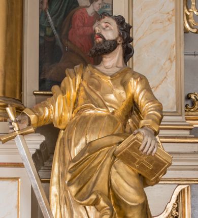 Zdjęcie nr 1: Figura ścięta z tyłu, drążona. Święty ukazany frontalnie, z uniesioną głową skierowaną w prawo, w kontrapoście, o esowato wygiętej sylwetce, odchylonej lekko w tył. W prawej ręce trzyma miecz, zwrócony ostrzem w dół, lewą przytrzymuje na nodze księgę. Twarz ma pociągłą, o dużych, migdałowatych oczach, zadartym nosie i pełnych ustach z wysuniętą górną wargą. Twarz okolona krótką, rozwidloną brodą oraz falowanymi włosami opadającymi na kark. Święty ubrany jest w sięgającą stóp tunikę z długimi rękawami, przepasaną szarfą oraz płaszcz zwinięty wokół prawego ramienia i opadający na lewą nogę. Polichromia ciała naturalistyczna, szaty i atrybuty złocone, detal srebrzony.