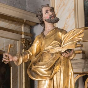 Zdjęcie nr 1: Figura ścięta z tyłu, drążona, ustawiona na niskiej podstawie. Święty ukazany frontalnie, z głową skierowaną w lewo, stoi w kontrapoście. Lewą ręką podtrzymuje otwartą księgę, prawą wyciąga w bok, a w dłoni trzyma klucz. Twarz ma pociągłą, o starczych rysach, migdałowatych oczach skierowanych w górę, lekko garbatym nosie oraz otwartych ustach z widoczną linią zębów. Okolona jest brodą, silnie wysuniętą do przodu oraz krótkimi, kręconymi włosami. Ubrany jest w tunikę z kołnierzykiem, przepasaną w talii, ściśle przylegającą do ciała w partii torsu oraz płaszcz przepasany diagonalnie przez lewe ramię i otaczający postać z wywiniętą połą na prawym boku. Polichromia ciała naturalistyczna, włosy ciemnobrązowe, szaty i atrybuty złocone. 

