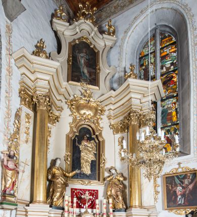 Zdjęcie nr 1: Nastawa ołtarzowa architektoniczna, jednoosiowa, jednokondygnacyjna ze zwieńczeniem, ustawiona na dwustrefowym cokole z wyodrębnionymi prostopadłościanami. Ołtarz kamienny, prostopadłościenny, w drewnianej obudowie. Mensa kamienna z marmurowym portatylem. Antepedium drewniane, w kształcie leżącego prostokąta, ujęte profilowaną ramą, z płaskorzeźbionym monogram IHS w glorii oraz fragmentami ornamentu roślinnego. Tabernakulum w formie prostopadłościennej skrzynki o wypukłym licu, flankowanej parą kolumienek na cokołach, ustawionych pod kątem, dźwigających woluty oraz gzyms przyjmujący formę łuku segmentowego nadwieszonego. Drzwiczki w kształcie stojącego prostokąta zamkniętego łukiem półkolistym, w opasce, z płaskorzeźbionym przedstawieniem baranka apokaliptycznego, leżącego na księdze, w glorii. Nastawa ujęta dwiema parami pilastrów dekorowanych rocaille'em i stojącą pomiędzy nimi parą kolumn o kapitelach kompozytowych dźwigających pełne belkowanie, wyłamane na ich osi, przerwane pośrodku. Na belkowaniu ustawione dwa wazony. W polu centralnym głęboka wnęka w formie stojącego prostokąta zamkniętego łukiem półkolistym nadwieszonym z uskokiem, ujęta profilowaną ramą, z obrazem św. Małgorzaty w osobnej profilowanej ramie o kształcie stojącego prostokąta zamkniętego ornamentalnym łukiem. Ponad nią, w partii belkowania rokokowy kartusz z rytą koroną i liśćmi palmy, a poniżej prostokątna płycina z wotami. Pole flankowane figurami św. Jana Ewangelisty i Matki Boskiej stojącymi na ćwierćkolistych cokołach. Nastawa ujęta uszami utworzonymi z rocaille'u. Zwieńczenie w formie stojącego prostokąta o wklęsłych bokach, ze spływami z uszakami po bokach, zamknięte gzymsem przyjmującym formę łuku segmentowego nadwieszonego z uskokiem, wyłamanego przy brzegach, dekorowanego rocaille'em. W polu obraz św. Małgorzaty ujęty profilowaną ramą w kształcie stojącego prostokąta zamkniętego łukiem segmentowym nadwieszonym z uskokiem. 
Struktura marmoryzowana w kolorze beżowym; ornamentyka, profile i kolumny złocone.