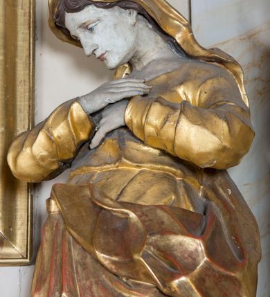 Zdjęcie nr 14: Nastawa ołtarzowa architektoniczna, jednoosiowa, jednokondygnacyjna ze zwieńczeniem, ustawiona na dwustrefowym cokole z wyodrębnionymi prostopadłościanami. Ołtarz kamienny, prostopadłościenny, w drewnianej obudowie. Mensa kamienna z marmurowym portatylem. Antepedium drewniane, w kształcie leżącego prostokąta, ujęte profilowaną ramą, z płaskorzeźbionym monogram IHS w glorii oraz fragmentami ornamentu roślinnego. Tabernakulum w formie prostopadłościennej skrzynki o wypukłym licu, flankowanej parą kolumienek na cokołach, ustawionych pod kątem, dźwigających woluty oraz gzyms przyjmujący formę łuku segmentowego nadwieszonego. Drzwiczki w kształcie stojącego prostokąta zamkniętego łukiem półkolistym, w opasce, z płaskorzeźbionym przedstawieniem baranka apokaliptycznego, leżącego na księdze, w glorii. Nastawa ujęta dwiema parami pilastrów dekorowanych rocaille&#039;em i stojącą pomiędzy nimi parą kolumn o kapitelach kompozytowych dźwigających pełne belkowanie, wyłamane na ich osi, przerwane pośrodku. Na belkowaniu ustawione dwa wazony. W polu centralnym głęboka wnęka w formie stojącego prostokąta zamkniętego łukiem półkolistym nadwieszonym z uskokiem, ujęta profilowaną ramą, z obrazem św. Małgorzaty w osobnej profilowanej ramie o kształcie stojącego prostokąta zamkniętego ornamentalnym łukiem. Ponad nią, w partii belkowania rokokowy kartusz z rytą koroną i liśćmi palmy, a poniżej prostokątna płycina z wotami. Pole flankowane figurami św. Jana Ewangelisty i Matki Boskiej stojącymi na ćwierćkolistych cokołach. Nastawa ujęta uszami utworzonymi z rocaille&#039;u. Zwieńczenie w formie stojącego prostokąta o wklęsłych bokach, ze spływami z uszakami po bokach, zamknięte gzymsem przyjmującym formę łuku segmentowego nadwieszonego z uskokiem, wyłamanego przy brzegach, dekorowanego rocaille&#039;em. W polu obraz św. Małgorzaty ujęty profilowaną ramą w kształcie stojącego prostokąta zamkniętego łukiem segmentowym nadwieszonym z uskokiem. 
Struktura marmoryzowana w kolorze beżowym; ornamentyka, profile i kolumny złocone.