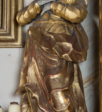 Zdjęcie nr 12: Nastawa ołtarzowa architektoniczna, jednoosiowa, jednokondygnacyjna ze zwieńczeniem, ustawiona na dwustrefowym cokole z wyodrębnionymi prostopadłościanami. Ołtarz kamienny, prostopadłościenny, w drewnianej obudowie. Mensa kamienna z marmurowym portatylem. Antepedium drewniane, w kształcie leżącego prostokąta, ujęte profilowaną ramą, z płaskorzeźbionym monogram IHS w glorii oraz fragmentami ornamentu roślinnego. Tabernakulum w formie prostopadłościennej skrzynki o wypukłym licu, flankowanej parą kolumienek na cokołach, ustawionych pod kątem, dźwigających woluty oraz gzyms przyjmujący formę łuku segmentowego nadwieszonego. Drzwiczki w kształcie stojącego prostokąta zamkniętego łukiem półkolistym, w opasce, z płaskorzeźbionym przedstawieniem baranka apokaliptycznego, leżącego na księdze, w glorii. Nastawa ujęta dwiema parami pilastrów dekorowanych rocaille'em i stojącą pomiędzy nimi parą kolumn o kapitelach kompozytowych dźwigających pełne belkowanie, wyłamane na ich osi, przerwane pośrodku. Na belkowaniu ustawione dwa wazony. W polu centralnym głęboka wnęka w formie stojącego prostokąta zamkniętego łukiem półkolistym nadwieszonym z uskokiem, ujęta profilowaną ramą, z obrazem św. Małgorzaty w osobnej profilowanej ramie o kształcie stojącego prostokąta zamkniętego ornamentalnym łukiem. Ponad nią, w partii belkowania rokokowy kartusz z rytą koroną i liśćmi palmy, a poniżej prostokątna płycina z wotami. Pole flankowane figurami św. Jana Ewangelisty i Matki Boskiej stojącymi na ćwierćkolistych cokołach. Nastawa ujęta uszami utworzonymi z rocaille'u. Zwieńczenie w formie stojącego prostokąta o wklęsłych bokach, ze spływami z uszakami po bokach, zamknięte gzymsem przyjmującym formę łuku segmentowego nadwieszonego z uskokiem, wyłamanego przy brzegach, dekorowanego rocaille'em. W polu obraz św. Małgorzaty ujęty profilowaną ramą w kształcie stojącego prostokąta zamkniętego łukiem segmentowym nadwieszonym z uskokiem. 
Struktura marmoryzowana w kolorze beżowym; ornamentyka, profile i kolumny złocone.