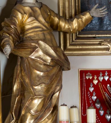 Zdjęcie nr 13: Nastawa ołtarzowa architektoniczna, jednoosiowa, jednokondygnacyjna ze zwieńczeniem, ustawiona na dwustrefowym cokole z wyodrębnionymi prostopadłościanami. Ołtarz kamienny, prostopadłościenny, w drewnianej obudowie. Mensa kamienna z marmurowym portatylem. Antepedium drewniane, w kształcie leżącego prostokąta, ujęte profilowaną ramą, z płaskorzeźbionym monogram IHS w glorii oraz fragmentami ornamentu roślinnego. Tabernakulum w formie prostopadłościennej skrzynki o wypukłym licu, flankowanej parą kolumienek na cokołach, ustawionych pod kątem, dźwigających woluty oraz gzyms przyjmujący formę łuku segmentowego nadwieszonego. Drzwiczki w kształcie stojącego prostokąta zamkniętego łukiem półkolistym, w opasce, z płaskorzeźbionym przedstawieniem baranka apokaliptycznego, leżącego na księdze, w glorii. Nastawa ujęta dwiema parami pilastrów dekorowanych rocaille'em i stojącą pomiędzy nimi parą kolumn o kapitelach kompozytowych dźwigających pełne belkowanie, wyłamane na ich osi, przerwane pośrodku. Na belkowaniu ustawione dwa wazony. W polu centralnym głęboka wnęka w formie stojącego prostokąta zamkniętego łukiem półkolistym nadwieszonym z uskokiem, ujęta profilowaną ramą, z obrazem św. Małgorzaty w osobnej profilowanej ramie o kształcie stojącego prostokąta zamkniętego ornamentalnym łukiem. Ponad nią, w partii belkowania rokokowy kartusz z rytą koroną i liśćmi palmy, a poniżej prostokątna płycina z wotami. Pole flankowane figurami św. Jana Ewangelisty i Matki Boskiej stojącymi na ćwierćkolistych cokołach. Nastawa ujęta uszami utworzonymi z rocaille'u. Zwieńczenie w formie stojącego prostokąta o wklęsłych bokach, ze spływami z uszakami po bokach, zamknięte gzymsem przyjmującym formę łuku segmentowego nadwieszonego z uskokiem, wyłamanego przy brzegach, dekorowanego rocaille'em. W polu obraz św. Małgorzaty ujęty profilowaną ramą w kształcie stojącego prostokąta zamkniętego łukiem segmentowym nadwieszonym z uskokiem. 
Struktura marmoryzowana w kolorze beżowym; ornamentyka, profile i kolumny złocone.