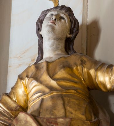 Zdjęcie nr 17: Nastawa ołtarzowa architektoniczna, jednoosiowa, jednokondygnacyjna ze zwieńczeniem, ustawiona na dwustrefowym cokole z wyodrębnionymi prostopadłościanami. Ołtarz kamienny, prostopadłościenny, w drewnianej obudowie. Mensa kamienna z marmurowym portatylem. Antepedium drewniane, w kształcie leżącego prostokąta, ujęte profilowaną ramą, z płaskorzeźbionym monogram IHS w glorii oraz fragmentami ornamentu roślinnego. Tabernakulum w formie prostopadłościennej skrzynki o wypukłym licu, flankowanej parą kolumienek na cokołach, ustawionych pod kątem, dźwigających woluty oraz gzyms przyjmujący formę łuku segmentowego nadwieszonego. Drzwiczki w kształcie stojącego prostokąta zamkniętego łukiem półkolistym, w opasce, z płaskorzeźbionym przedstawieniem baranka apokaliptycznego, leżącego na księdze, w glorii. Nastawa ujęta dwiema parami pilastrów dekorowanych rocaille'em i stojącą pomiędzy nimi parą kolumn o kapitelach kompozytowych dźwigających pełne belkowanie, wyłamane na ich osi, przerwane pośrodku. Na belkowaniu ustawione dwa wazony. W polu centralnym głęboka wnęka w formie stojącego prostokąta zamkniętego łukiem półkolistym nadwieszonym z uskokiem, ujęta profilowaną ramą, z obrazem św. Małgorzaty w osobnej profilowanej ramie o kształcie stojącego prostokąta zamkniętego ornamentalnym łukiem. Ponad nią, w partii belkowania rokokowy kartusz z rytą koroną i liśćmi palmy, a poniżej prostokątna płycina z wotami. Pole flankowane figurami św. Jana Ewangelisty i Matki Boskiej stojącymi na ćwierćkolistych cokołach. Nastawa ujęta uszami utworzonymi z rocaille'u. Zwieńczenie w formie stojącego prostokąta o wklęsłych bokach, ze spływami z uszakami po bokach, zamknięte gzymsem przyjmującym formę łuku segmentowego nadwieszonego z uskokiem, wyłamanego przy brzegach, dekorowanego rocaille'em. W polu obraz św. Małgorzaty ujęty profilowaną ramą w kształcie stojącego prostokąta zamkniętego łukiem segmentowym nadwieszonym z uskokiem. 
Struktura marmoryzowana w kolorze beżowym; ornamentyka, profile i kolumny złocone.