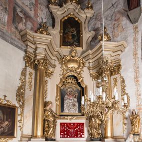 Zdjęcie nr 1: Nastawa ołtarzowa architektoniczna, jednoosiowa, jednokondygnacyjna ze zwieńczeniem, ustawiona na dwustrefowym cokole z wyodrębnionymi prostopadłościanami. Ołtarz kamienny, prostopadłościenny, w drewnianej obudowie. Mensa kamienna z marmurowym portatylem. Antepedium drewniane, w kształcie leżącego prostokąta, ujęte profilowaną ramą, z płaskorzeźbionym monogramem maryjnym oraz fragmentami ornamentu roślinnego. Tabernakulum w kształcie prostopadłościennej skrzynki o wypukłym licu, flankowanej parą kolumienek na cokołach, ustawionych pod kątem, dźwigających woluty oraz gzyms przyjmujący formę łuku segmentowego nadwieszonego. Drzwiczki w kształcie stojącego prostokąta zamkniętego łukiem półkolistym, w opasce, z płaskorzeźbionym przedstawieniem baranka apokaliptycznego, leżącego na księdze, w glorii. Nastawa ujęta dwiema parami pilastrów dekorowanych rocaille'em i stojącą pomiędzy nimi parą kolumn o kapitelach kompozytowych dźwigających pełne belkowanie, wyłamane na ich osi, przerwane pośrodku. Na belkowaniu ustawione dwa wazony. W polu centralnym głęboka wnęka w formie stojącego prostokąta zamkniętego łukiem półkolistym nadwieszonym z uskokiem, ujęta profilowaną ramą, z obrazem Matki Boskiej z Dzieciątkiem w osobnej profilowanej ramie o kształcie stojącego prostokąta zamkniętego ornamentalnym łukiem. Ponad nią, w partii belkowania rokokowy kartusz z rytym monogramem Marii, a poniżej prostokątna płycina z wotami. Pole flankowane dwiema figurami kobiet stojącymi na ćwierćkolistych cokołach. Nastawa ujęta uszami utworzonymi z rocaille'u. Zwieńczenie w formie stojącego prostokąta o wklęsłych bokach, ze spływami z uszakami po bokach, zamknięte gzymsem przyjmującym formę łuku segmentowego nadwieszonego z uskokiem, wyłamanego przy brzegach, dekorowanego rocaille'em. W polu obraz „Nauczanie Marii przez Joachima” ujęty profilowaną ramą w kształcie stojącego prostokąta zamkniętego łukiem segmentowym nadwieszonym z uskokiem. 
Struktura marmoryzowana w kolorze beżowym; ornamentyka, profile i kolumny złocone.