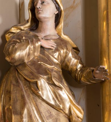 Zdjęcie nr 15: Nastawa ołtarzowa architektoniczna, jednoosiowa, jednokondygnacyjna ze zwieńczeniem, ustawiona na dwustrefowym cokole z wyodrębnionymi prostopadłościanami. Ołtarz kamienny, prostopadłościenny, w drewnianej obudowie. Mensa kamienna z marmurowym portatylem. Antepedium drewniane, w kształcie leżącego prostokąta, ujęte profilowaną ramą, z płaskorzeźbionym monogramem maryjnym oraz fragmentami ornamentu roślinnego. Tabernakulum w kształcie prostopadłościennej skrzynki o wypukłym licu, flankowanej parą kolumienek na cokołach, ustawionych pod kątem, dźwigających woluty oraz gzyms przyjmujący formę łuku segmentowego nadwieszonego. Drzwiczki w kształcie stojącego prostokąta zamkniętego łukiem półkolistym, w opasce, z płaskorzeźbionym przedstawieniem baranka apokaliptycznego, leżącego na księdze, w glorii. Nastawa ujęta dwiema parami pilastrów dekorowanych rocaille'em i stojącą pomiędzy nimi parą kolumn o kapitelach kompozytowych dźwigających pełne belkowanie, wyłamane na ich osi, przerwane pośrodku. Na belkowaniu ustawione dwa wazony. W polu centralnym głęboka wnęka w formie stojącego prostokąta zamkniętego łukiem półkolistym nadwieszonym z uskokiem, ujęta profilowaną ramą, z obrazem Matki Boskiej z Dzieciątkiem w osobnej profilowanej ramie o kształcie stojącego prostokąta zamkniętego ornamentalnym łukiem. Ponad nią, w partii belkowania rokokowy kartusz z rytym monogramem Marii, a poniżej prostokątna płycina z wotami. Pole flankowane dwiema figurami kobiet stojącymi na ćwierćkolistych cokołach. Nastawa ujęta uszami utworzonymi z rocaille'u. Zwieńczenie w formie stojącego prostokąta o wklęsłych bokach, ze spływami z uszakami po bokach, zamknięte gzymsem przyjmującym formę łuku segmentowego nadwieszonego z uskokiem, wyłamanego przy brzegach, dekorowanego rocaille'em. W polu obraz „Nauczanie Marii przez Joachima” ujęty profilowaną ramą w kształcie stojącego prostokąta zamkniętego łukiem segmentowym nadwieszonym z uskokiem. 
Struktura marmoryzowana w kolorze beżowym; ornamentyka, profile i kolumny złocone.