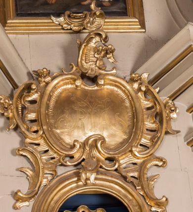Zdjęcie nr 23: Nastawa ołtarzowa architektoniczna, jednoosiowa, jednokondygnacyjna ze zwieńczeniem, ustawiona na dwustrefowym cokole z wyodrębnionymi prostopadłościanami. Ołtarz kamienny, prostopadłościenny, w drewnianej obudowie. Mensa kamienna z marmurowym portatylem. Antepedium drewniane, w kształcie leżącego prostokąta, ujęte profilowaną ramą, z płaskorzeźbionym monogramem maryjnym oraz fragmentami ornamentu roślinnego. Tabernakulum w kształcie prostopadłościennej skrzynki o wypukłym licu, flankowanej parą kolumienek na cokołach, ustawionych pod kątem, dźwigających woluty oraz gzyms przyjmujący formę łuku segmentowego nadwieszonego. Drzwiczki w kształcie stojącego prostokąta zamkniętego łukiem półkolistym, w opasce, z płaskorzeźbionym przedstawieniem baranka apokaliptycznego, leżącego na księdze, w glorii. Nastawa ujęta dwiema parami pilastrów dekorowanych rocaille'em i stojącą pomiędzy nimi parą kolumn o kapitelach kompozytowych dźwigających pełne belkowanie, wyłamane na ich osi, przerwane pośrodku. Na belkowaniu ustawione dwa wazony. W polu centralnym głęboka wnęka w formie stojącego prostokąta zamkniętego łukiem półkolistym nadwieszonym z uskokiem, ujęta profilowaną ramą, z obrazem Matki Boskiej z Dzieciątkiem w osobnej profilowanej ramie o kształcie stojącego prostokąta zamkniętego ornamentalnym łukiem. Ponad nią, w partii belkowania rokokowy kartusz z rytym monogramem Marii, a poniżej prostokątna płycina z wotami. Pole flankowane dwiema figurami kobiet stojącymi na ćwierćkolistych cokołach. Nastawa ujęta uszami utworzonymi z rocaille'u. Zwieńczenie w formie stojącego prostokąta o wklęsłych bokach, ze spływami z uszakami po bokach, zamknięte gzymsem przyjmującym formę łuku segmentowego nadwieszonego z uskokiem, wyłamanego przy brzegach, dekorowanego rocaille'em. W polu obraz „Nauczanie Marii przez Joachima” ujęty profilowaną ramą w kształcie stojącego prostokąta zamkniętego łukiem segmentowym nadwieszonym z uskokiem. 
Struktura marmoryzowana w kolorze beżowym; ornamentyka, profile i kolumny złocone.