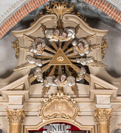 Zdjęcie nr 4: Nastawa architektoniczna, trójosiowa, jednokondygnacyjna ze zwieńczeniem, ustawiona na dwustrefowym cokole, z wyodrębnionymi dwoma prostopadłościanami. Ołtarz prostopadłościenny, z drewnianą mensą. Antepedium ujęte profilowaną ramą z monogramem IHS w polu. 
Osie nastawy wydzielone dwiema parami pilastrów oraz stojącymi przed środkową parą dwiema kolumnami ustawionymi na wydzielonych cokołach. Podpory podtrzymują wyłamujące się ponad nimi belkowanie z mocno wysuniętym gzymsem oraz fragmenty przerwanego przyczółka. Niemal całe pole środkowe wypełnia wnęka w formie stojącego prostokąta zamkniętego łukiem odcinkowym nadwieszonym, ujęta profilowaną ramą, z figurą Chrystusa Ukrzyżowanego. Nad nią rokokowy kartusz z monogramem IHS w polu. Pod nią, w partii predelli, scena z przypowieści o siewcy oraz Umywanie nóg. Na osiach bocznych po dwie arkady w dwóch rzędach ze scenami z życia św. Małgorzaty. Kondygnacja ujęta uszami utworzonymi z rocaille'u. Zwieńczenie w formie kwadratu, flankowane pilastrami przechodzącymi w woluty spływające na belkowanie, zamknięte dwoma odcinkami falowanego gzymsu, zamkniętego szczytem z rocaille'u. W polu, na tle prześwitu oko Opatrzności w otoku z obłoków i uskrzydlonych główek anielskich na tle glorii promienistej. Ołtarz flankowany wysokimi, wolno stojącymi postumentami z figurami św. Piotra i św. Pawła. Struktura polichromowana w odcieniach beżu. W partiach pól antepedium, cokołów, trzonów pilastrów i fryzu retabulum marmoryzacja w odcieniach beżu i brązu; kolumny, profile i ornamentyka złocone, detale srebrzone.  Z tyłu ołtarza tabliczka z napisem: „odnowienie kościoła r(oku) 1882 / z(acnie) w(ielmożnego) x(iędza) proboszcza i. Przybysia / w(ielmożnego) p(ana) Klaeskiego oraz szanownych […] i […] wykonawca tego malowania kościoła Jan Dutkiewicz / wraz czeladzią, Karol Jachimowicz i / Karol Dutkiewicz”.