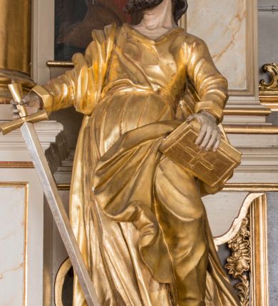 Zdjęcie nr 15: Nastawa architektoniczna, trójosiowa, jednokondygnacyjna ze zwieńczeniem, ustawiona na dwustrefowym cokole, z wyodrębnionymi dwoma prostopadłościanami. Ołtarz prostopadłościenny, z drewnianą mensą. Antepedium ujęte profilowaną ramą z monogramem IHS w polu. 
Osie nastawy wydzielone dwiema parami pilastrów oraz stojącymi przed środkową parą dwiema kolumnami ustawionymi na wydzielonych cokołach. Podpory podtrzymują wyłamujące się ponad nimi belkowanie z mocno wysuniętym gzymsem oraz fragmenty przerwanego przyczółka. Niemal całe pole środkowe wypełnia wnęka w formie stojącego prostokąta zamkniętego łukiem odcinkowym nadwieszonym, ujęta profilowaną ramą, z figurą Chrystusa Ukrzyżowanego. Nad nią rokokowy kartusz z monogramem IHS w polu. Pod nią, w partii predelli, scena z przypowieści o siewcy oraz Umywanie nóg. Na osiach bocznych po dwie arkady w dwóch rzędach ze scenami z życia św. Małgorzaty. Kondygnacja ujęta uszami utworzonymi z rocaille'u. Zwieńczenie w formie kwadratu, flankowane pilastrami przechodzącymi w woluty spływające na belkowanie, zamknięte dwoma odcinkami falowanego gzymsu, zamkniętego szczytem z rocaille'u. W polu, na tle prześwitu oko Opatrzności w otoku z obłoków i uskrzydlonych główek anielskich na tle glorii promienistej. Ołtarz flankowany wysokimi, wolno stojącymi postumentami z figurami św. Piotra i św. Pawła. Struktura polichromowana w odcieniach beżu. W partiach pól antepedium, cokołów, trzonów pilastrów i fryzu retabulum marmoryzacja w odcieniach beżu i brązu; kolumny, profile i ornamentyka złocone, detale srebrzone.  Z tyłu ołtarza tabliczka z napisem: „odnowienie kościoła r(oku) 1882 / z(acnie) w(ielmożnego) x(iędza) proboszcza i. Przybysia / w(ielmożnego) p(ana) Klaeskiego oraz szanownych […] i […] wykonawca tego malowania kościoła Jan Dutkiewicz / wraz czeladzią, Karol Jachimowicz i / Karol Dutkiewicz”.